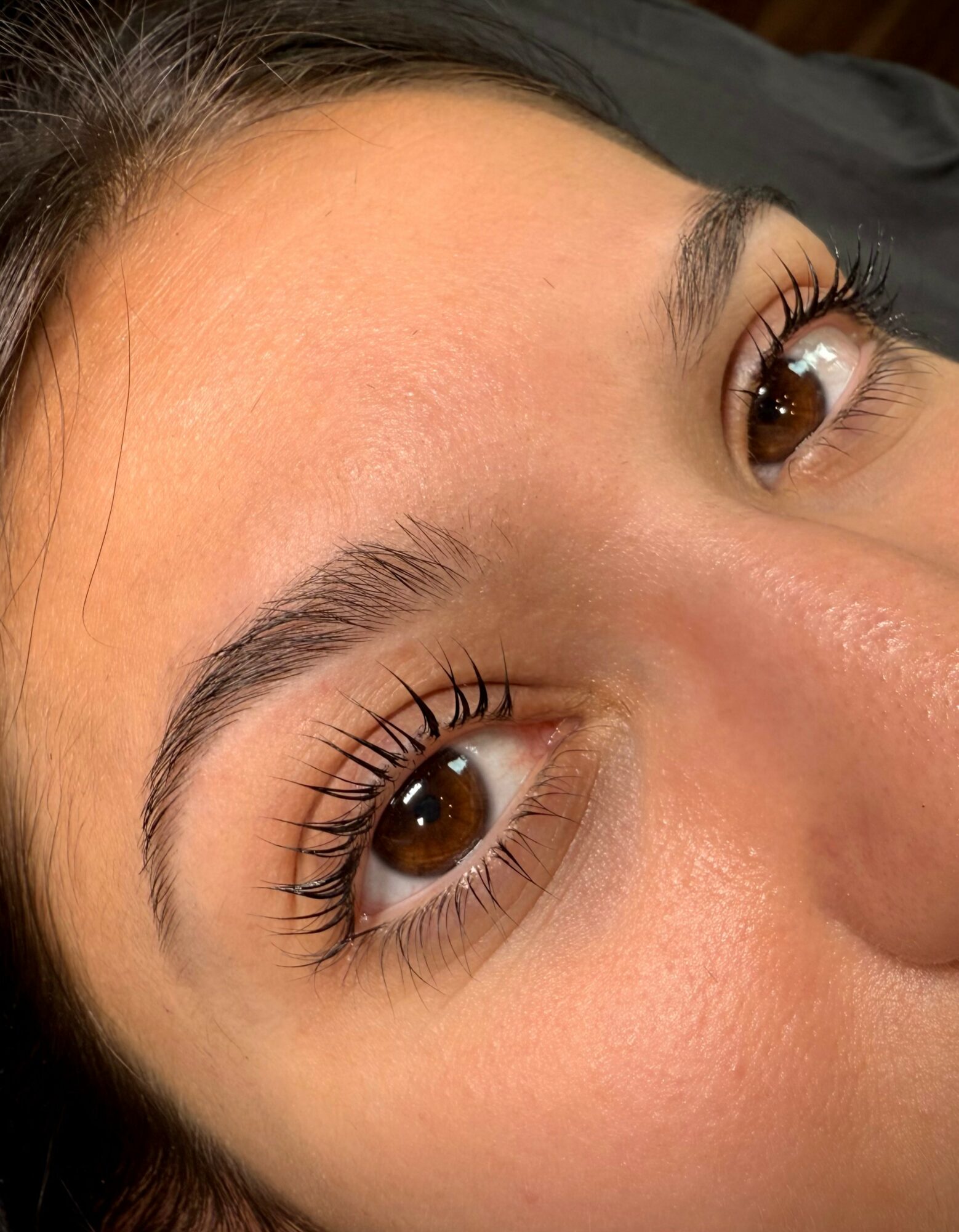 Close-up of a person's face focusing on eyes with long eyelashes and well-groomed eyebrows.