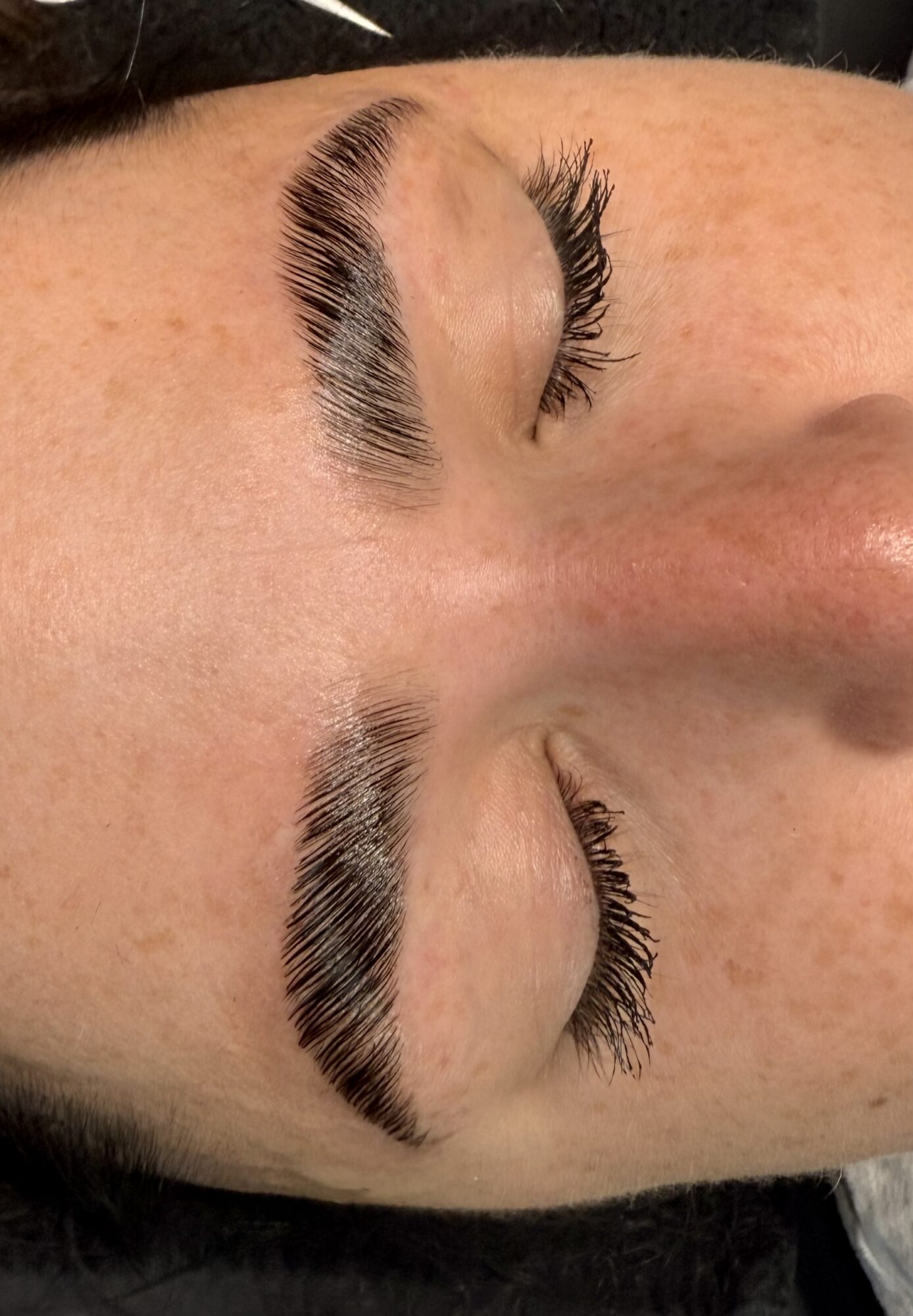 Close-up of closed eyes with long eyelashes and well-defined eyebrows.