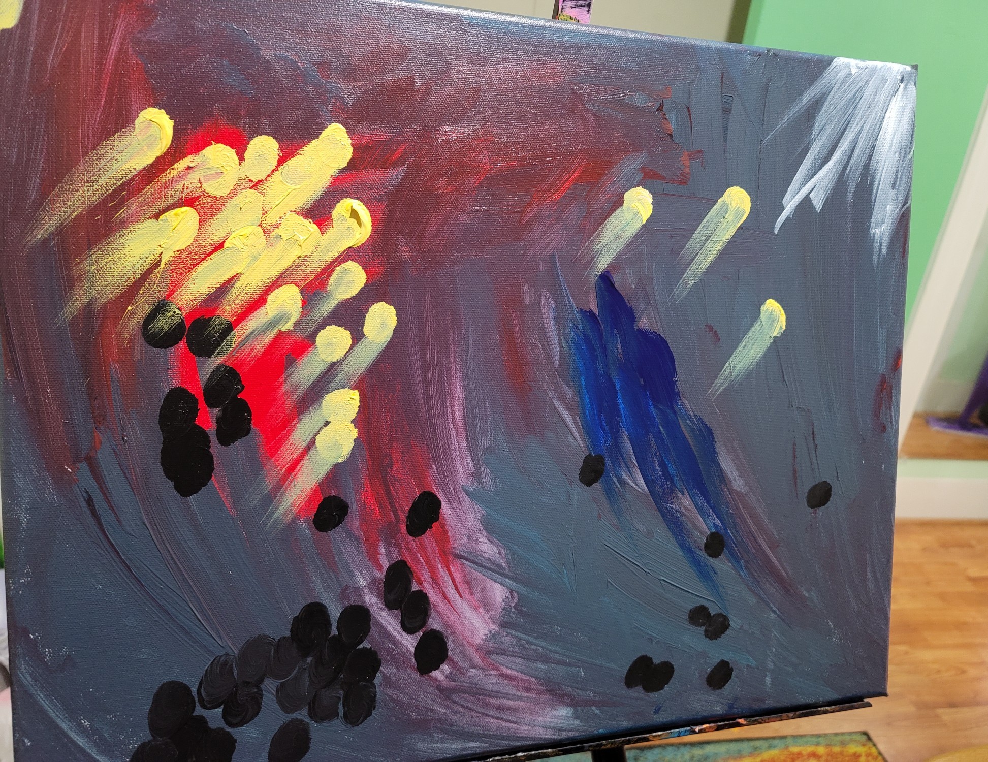 Abstract painting with yellow, red, blue, black, and white brushstrokes on canvas.