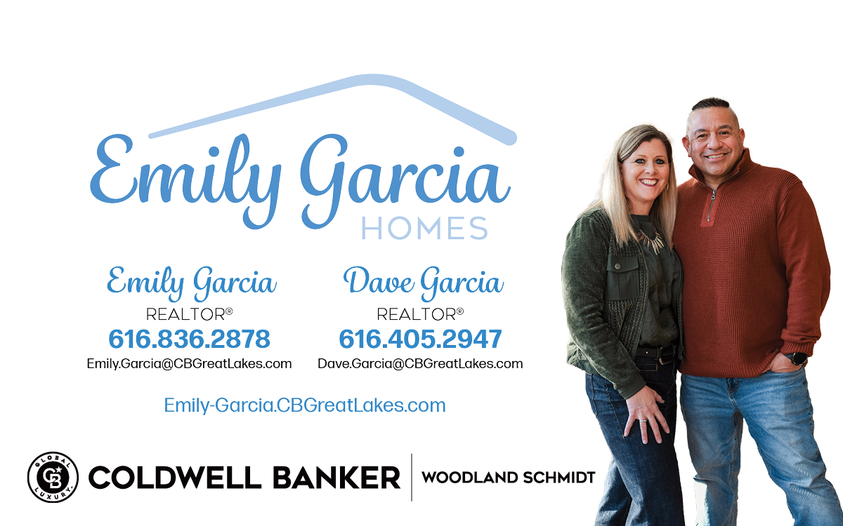 A woman and man stand together smiling, with a black background and blue text for Emily Garcia Homes.