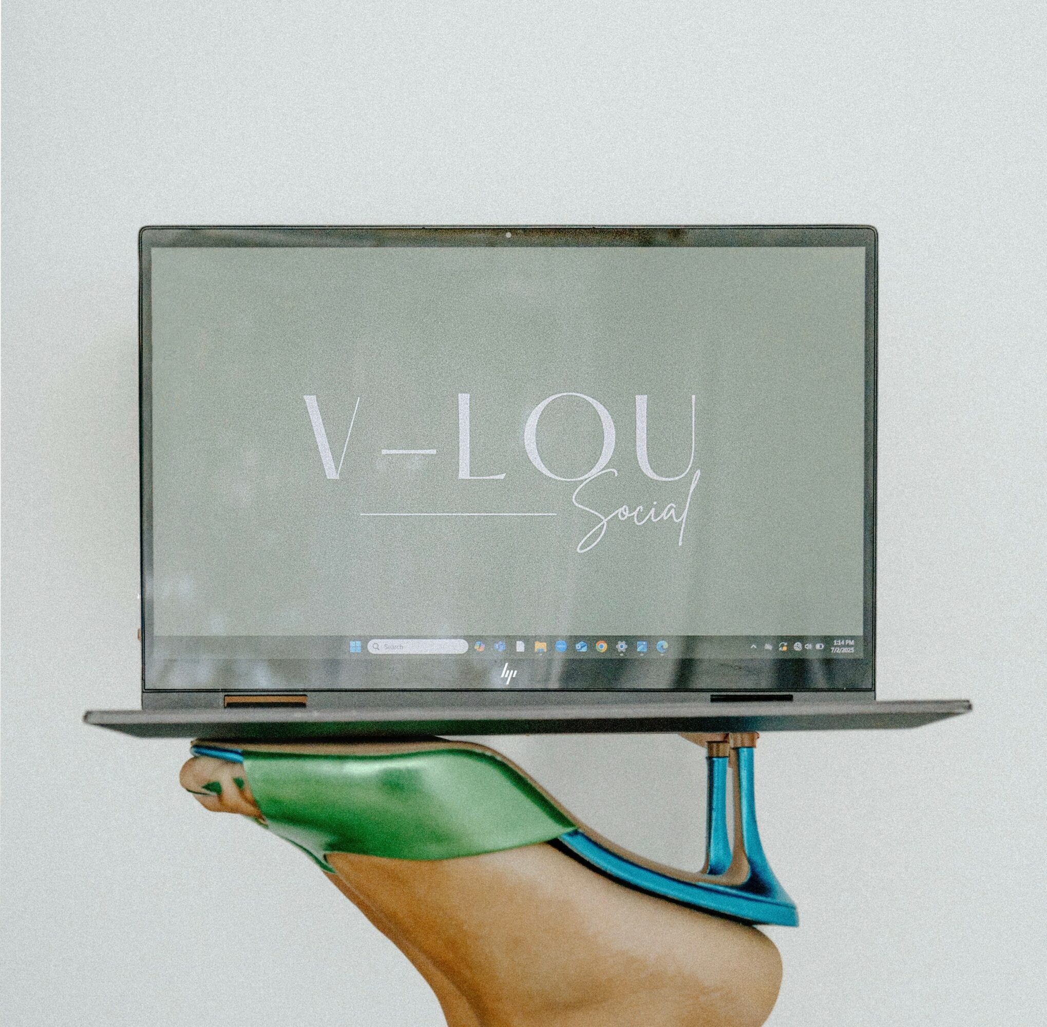 Person holding a laptop with a screen displaying text, against a plain background.