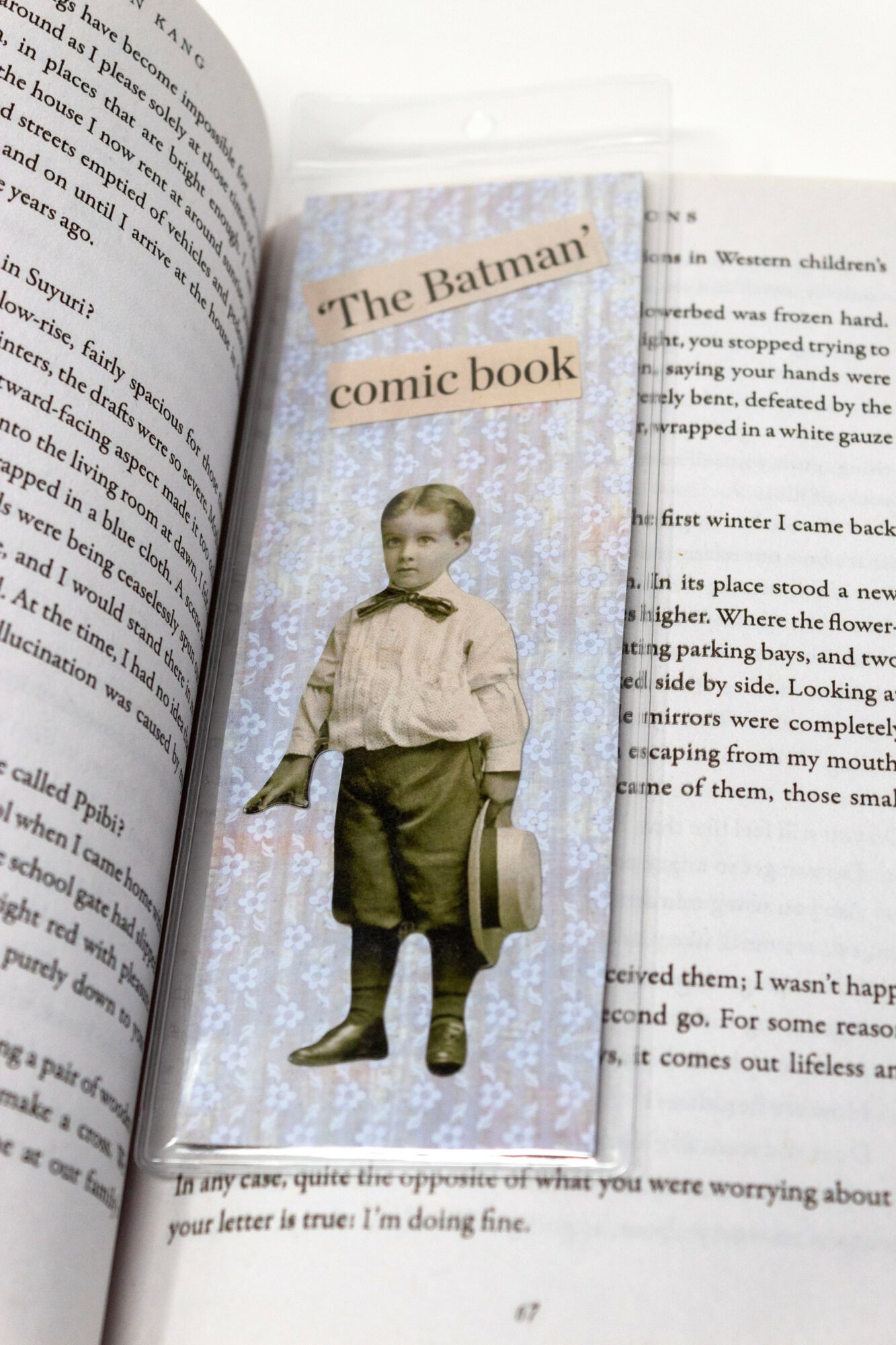 Page with a cutout of a young boy in vintage clothing holding a hat, with a background of light blue and white snowflakes.