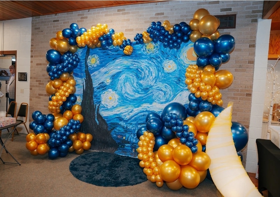 Decorative backdrop with balloons surrounding a Van Gogh-inspired starry night scene, including a crescent moon and dark landscape.