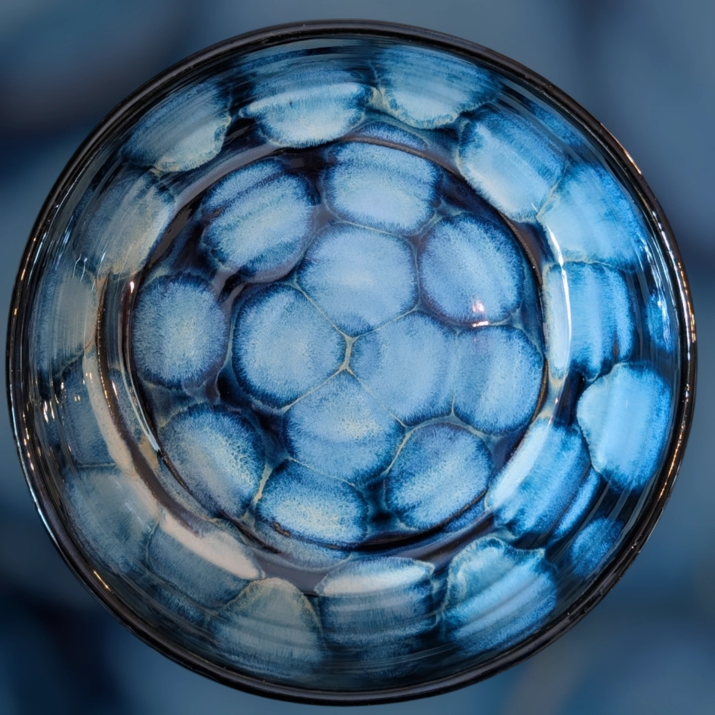 Top view of a glass with ice cubes, seen from above, with a blue background.