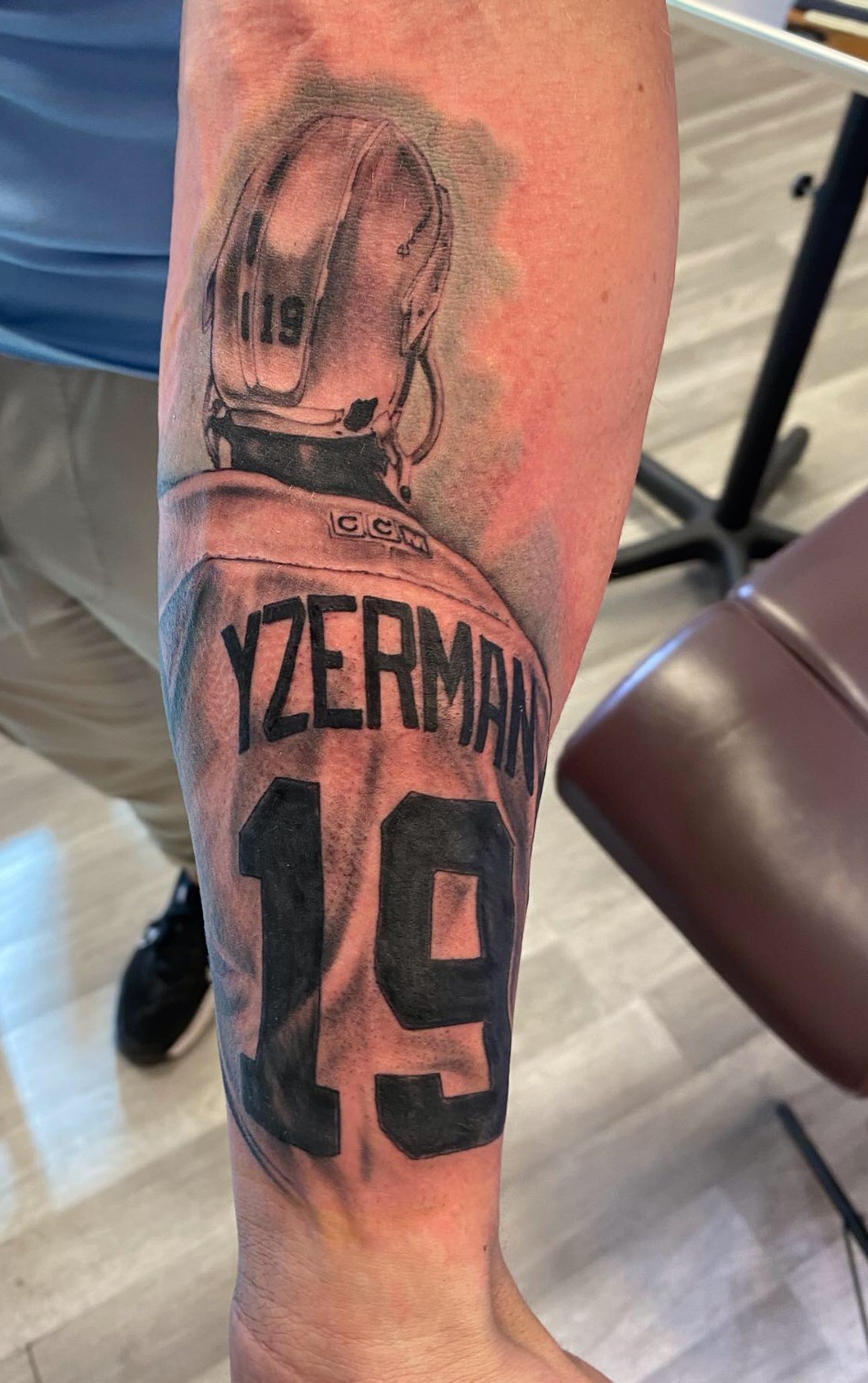 Tattoo of a baseball glove and ball above the name 'Yzermaan' and number 19 on a person's arm.