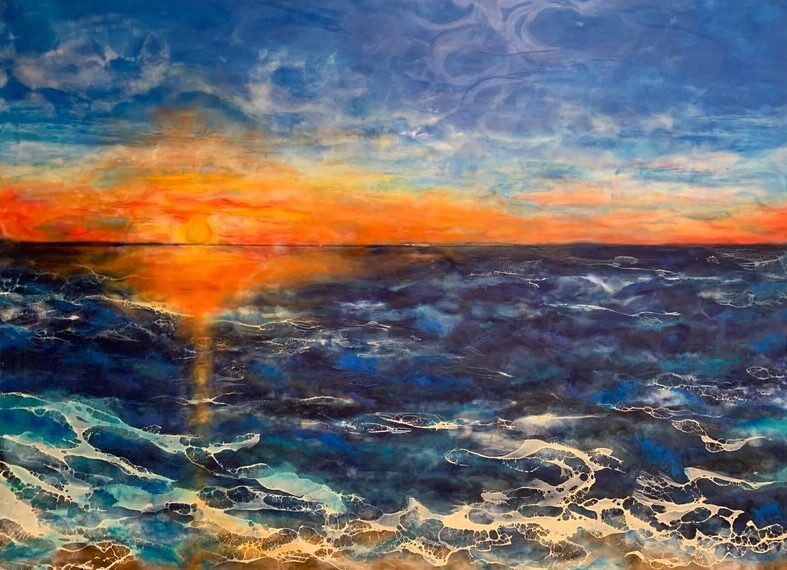 Sunset over ocean with colorful sky and waves, vibrant orange and blue hues, water reflecting sunset colors.