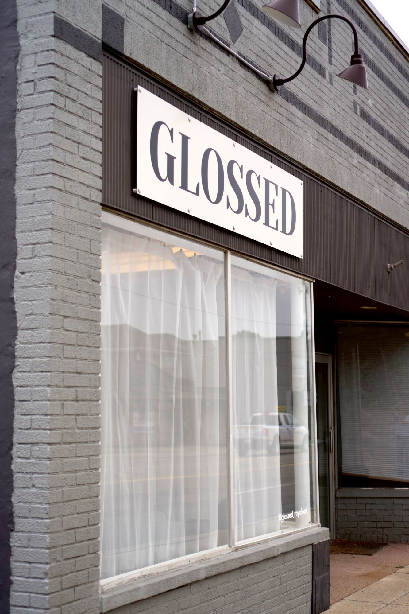 Closed storefront with large glass window and a sign that reads 'CLOSED'.