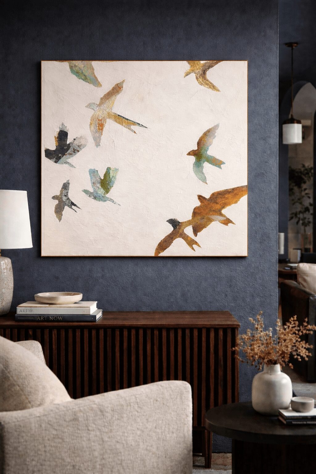 Wall art featuring colorful flying birds on a white background, hung above a wooden sideboard in a living room.