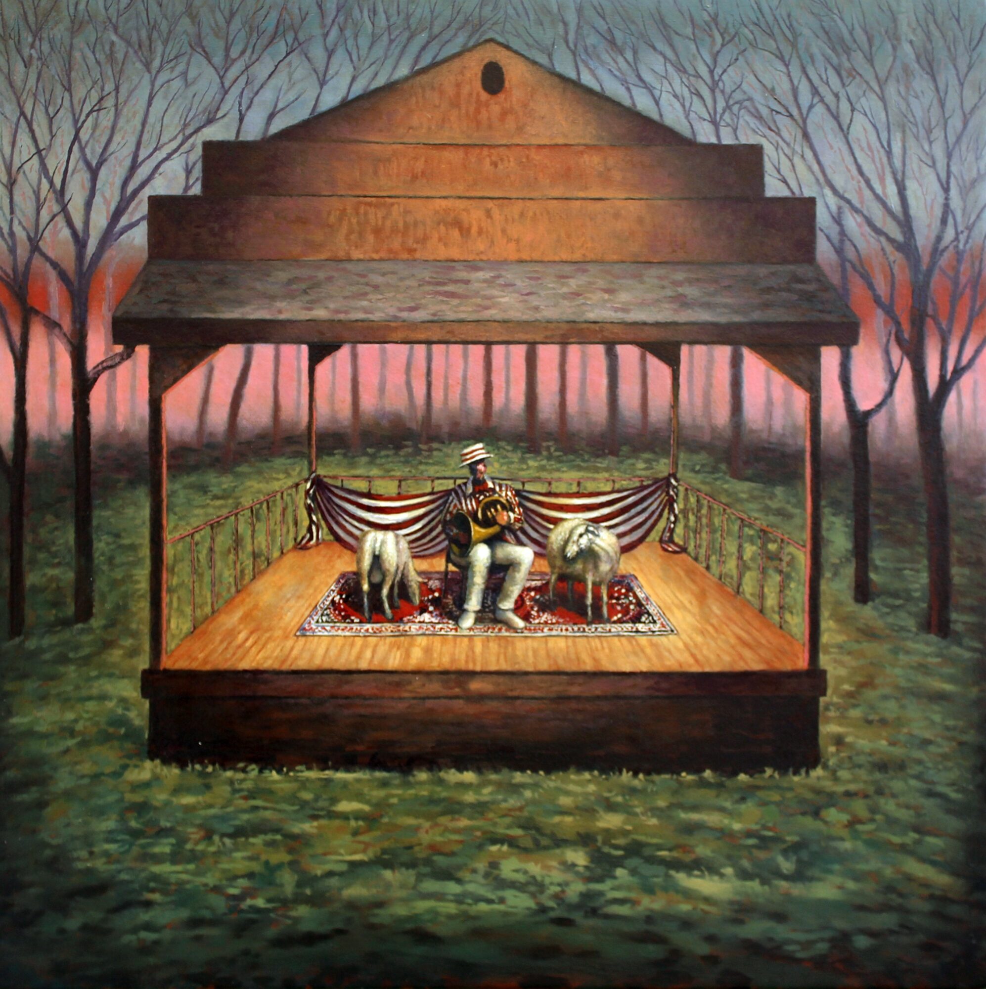 A puppet show stage with a performer and two puppets, set outdoors with trees in the background.