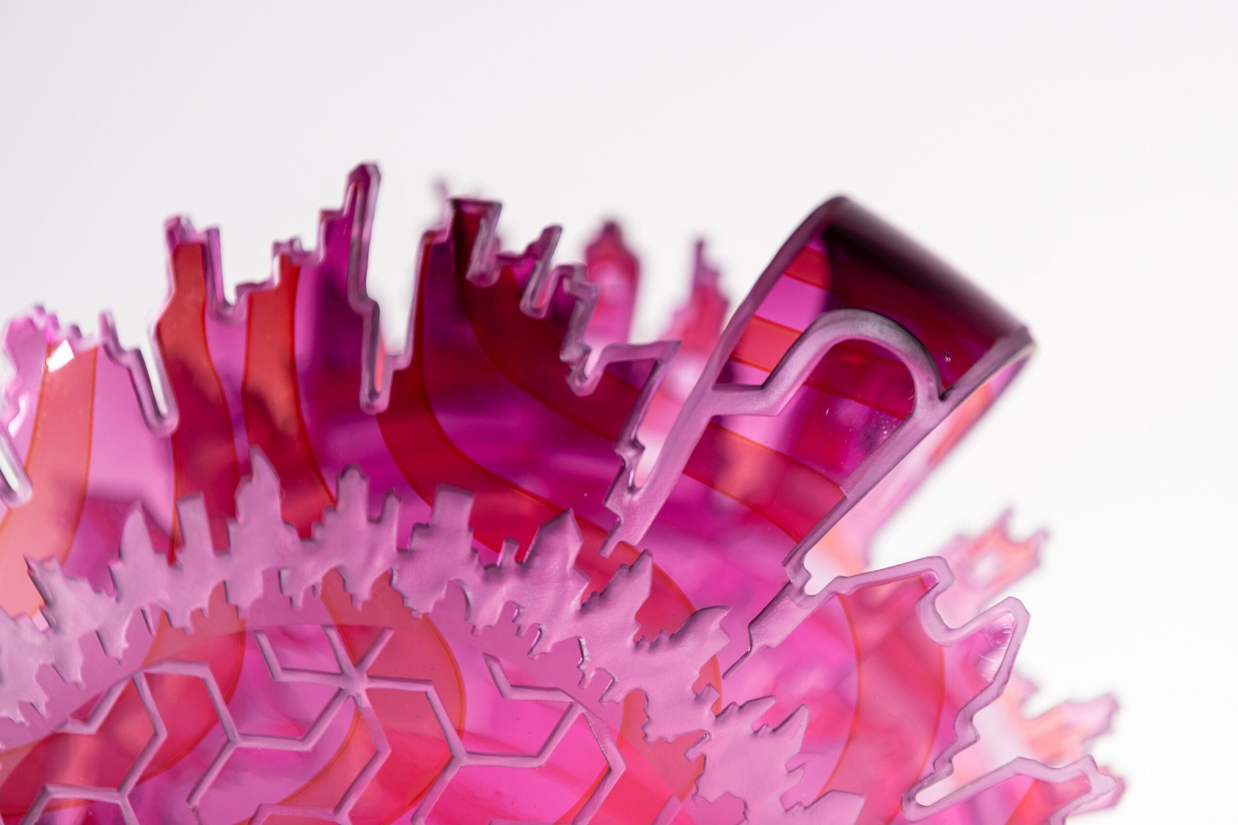 Close-up of a colorful, abstract, three-dimensional structure with pink and purple hues, resembling a spiky, geometric shape.