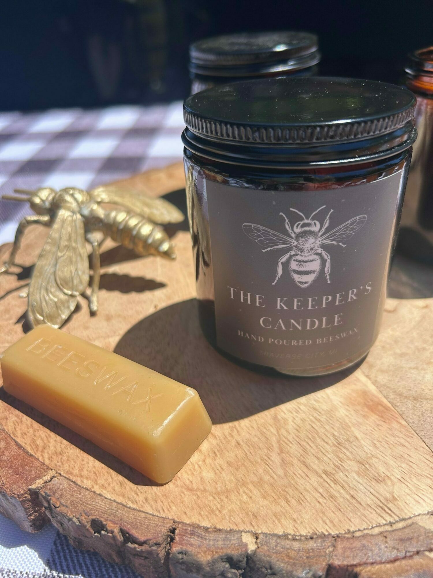 A jar labeled 'Milk Keepe' with a bee illustration, a bar of soap, and a small statue on a wooden surface.