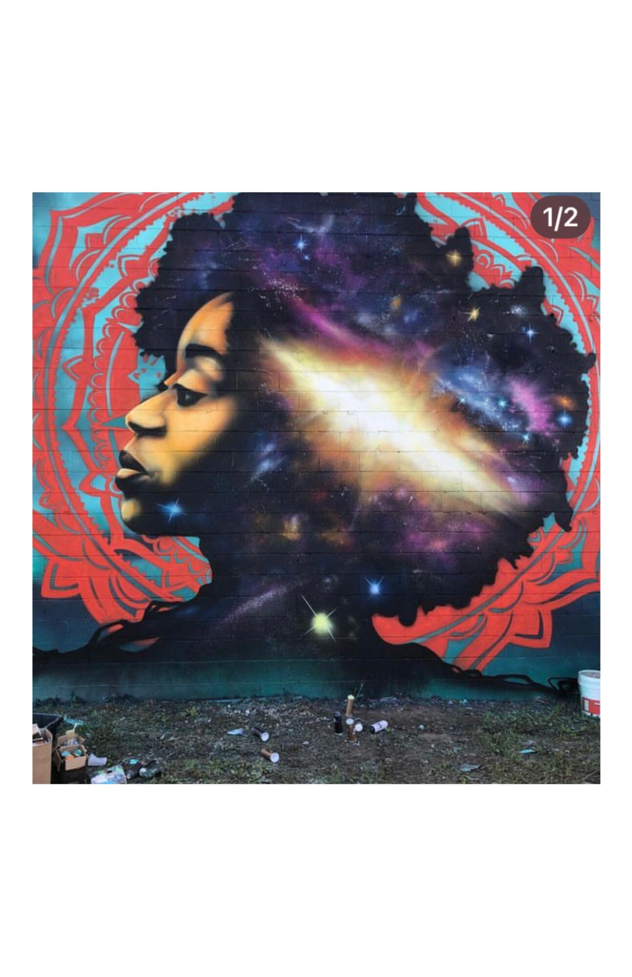 Mural of a woman's profile with a galaxy and cosmic elements in her hair, surrounded by red decorative patterns.