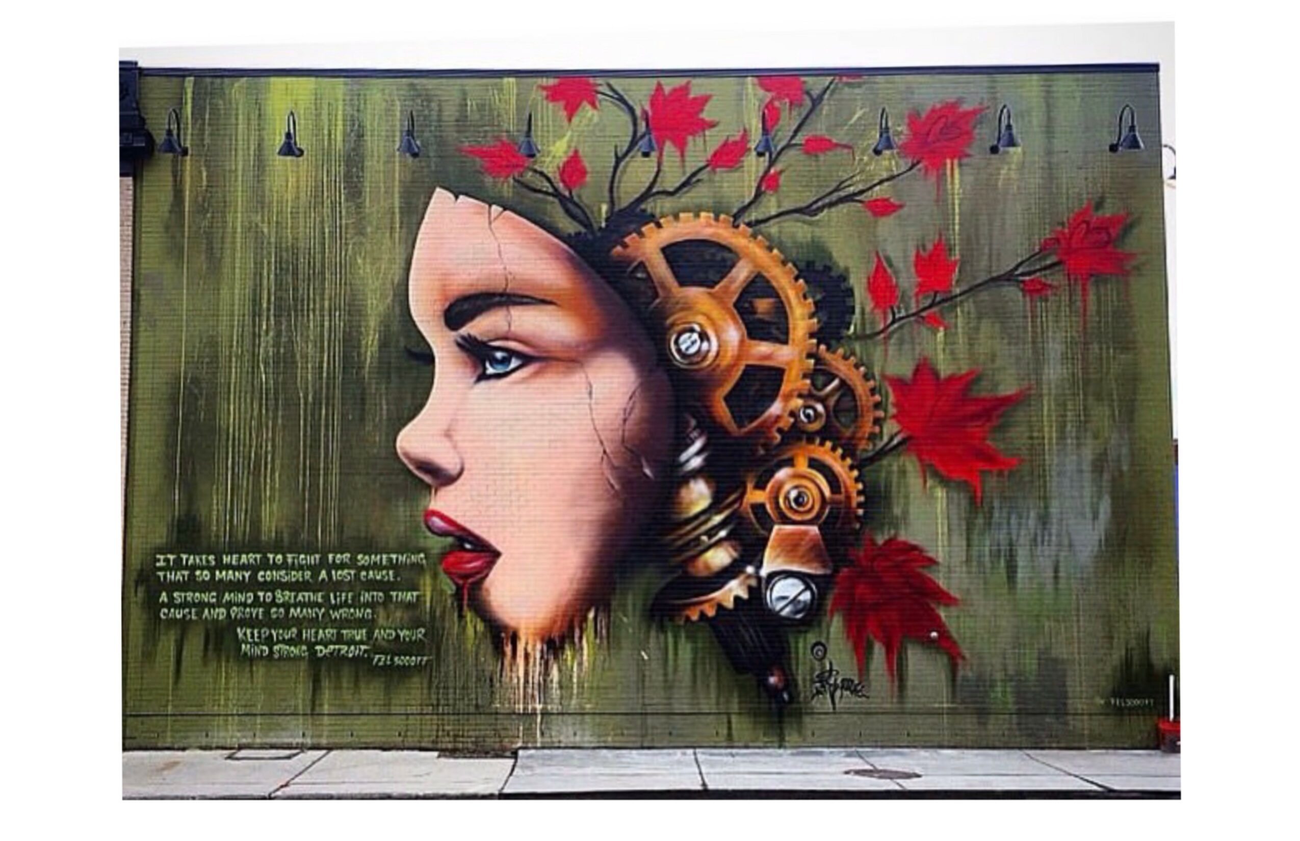 Street art mural of a woman's profile with mechanical gears and red leaves, on a green background.