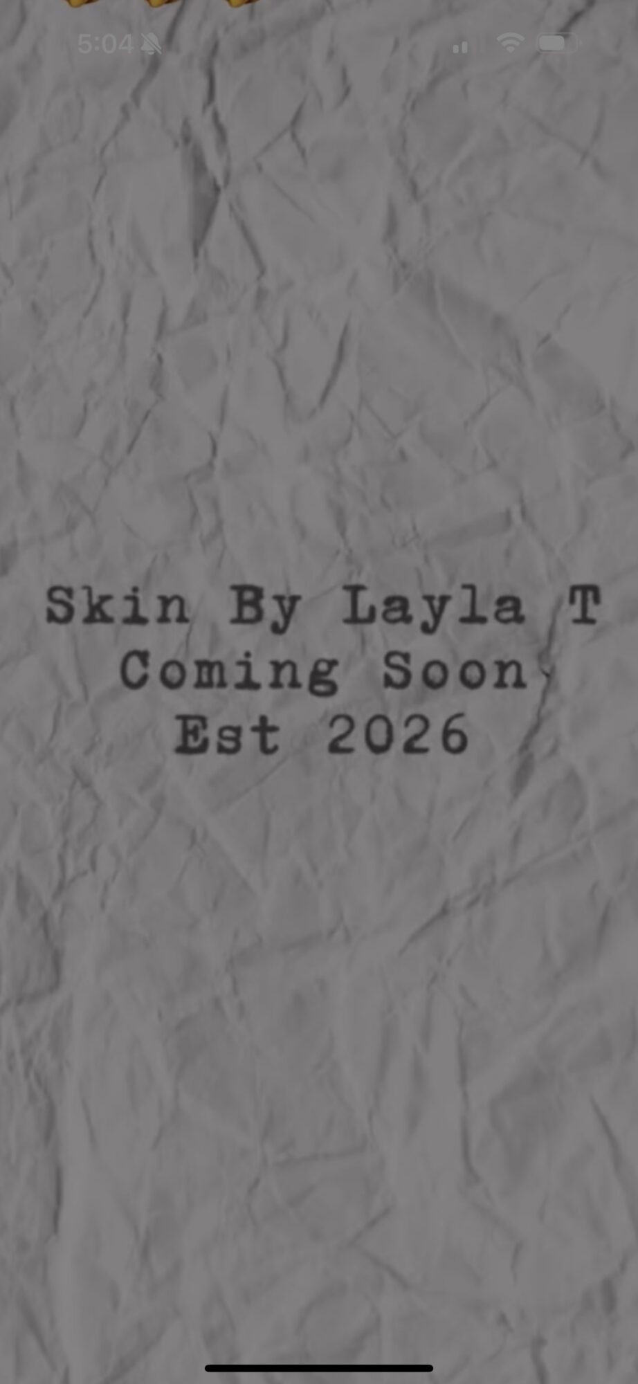 Text on crumpled paper reads: 'Skin By Layla T Coming Soon Est 2026'.