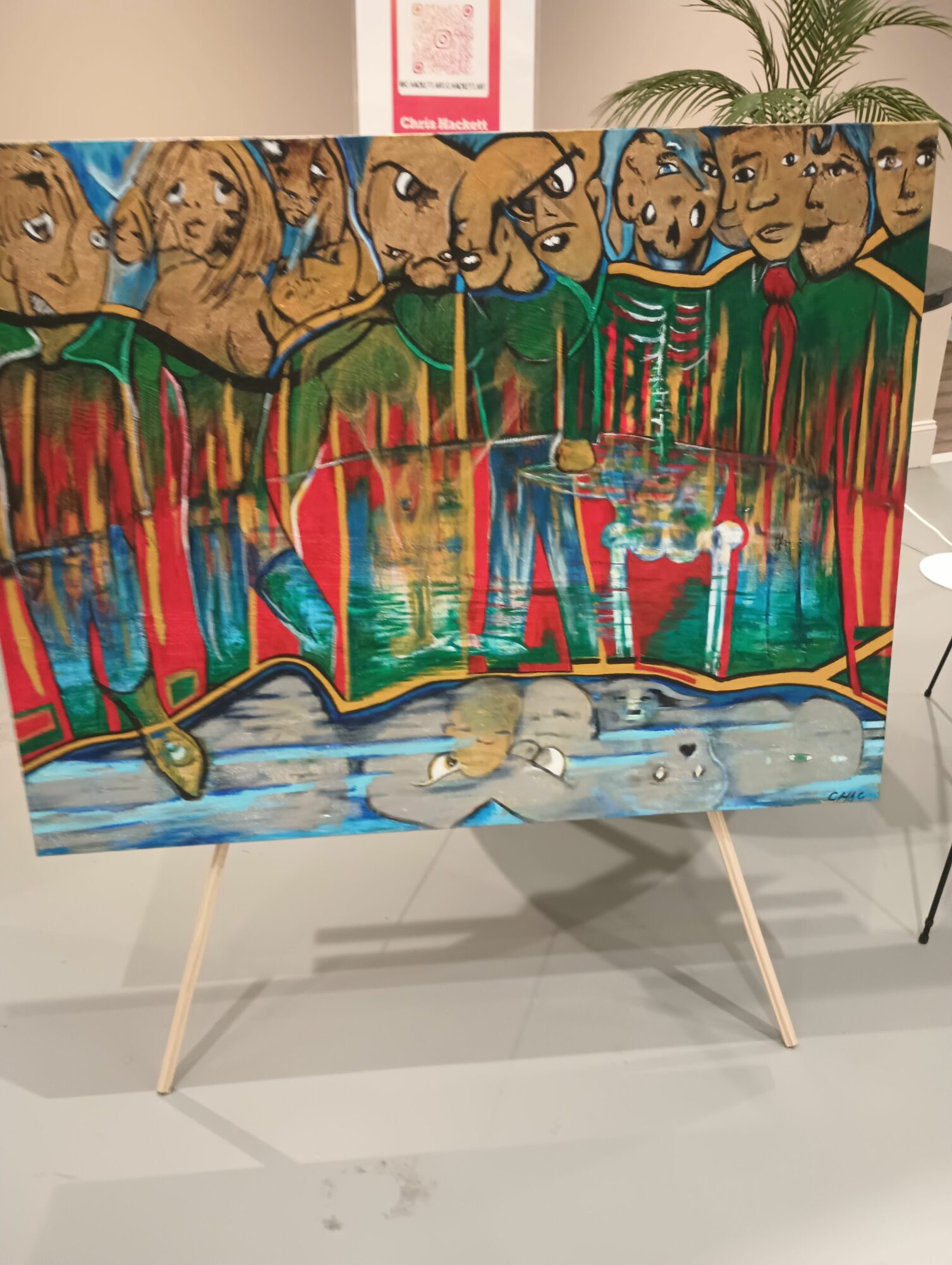 Colorful mural with dogs, trees, and a sky, painted on a rectangular surface supported by wooden legs, indoors.
