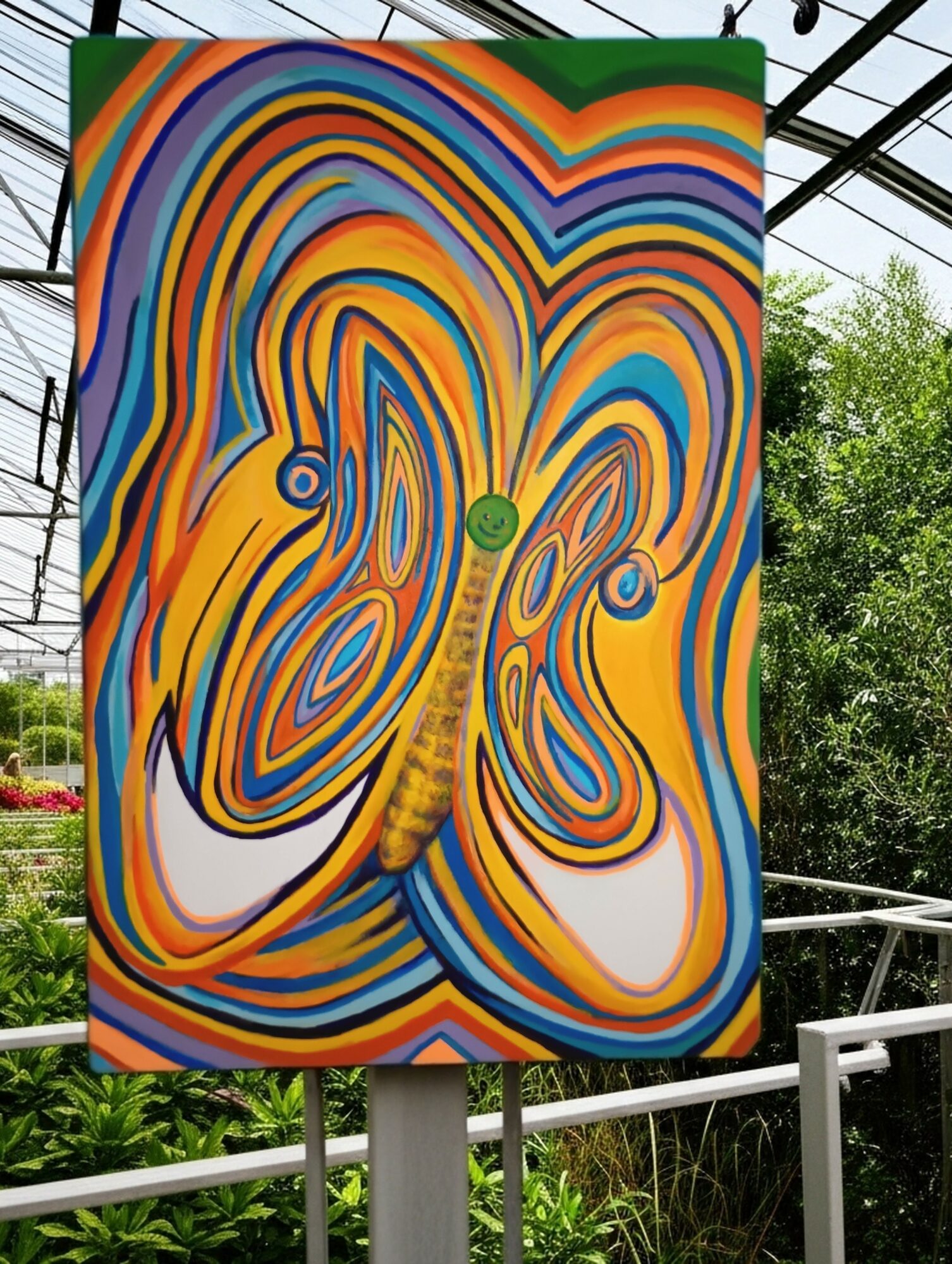 Colorful butterfly painting with swirling patterns and vibrant colors, displayed outdoors with greenery in the background.