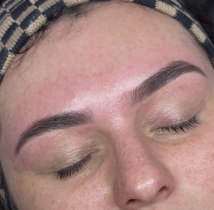 Close-up of a person's face with eyes closed, showing well-groomed eyebrows and smooth skin.