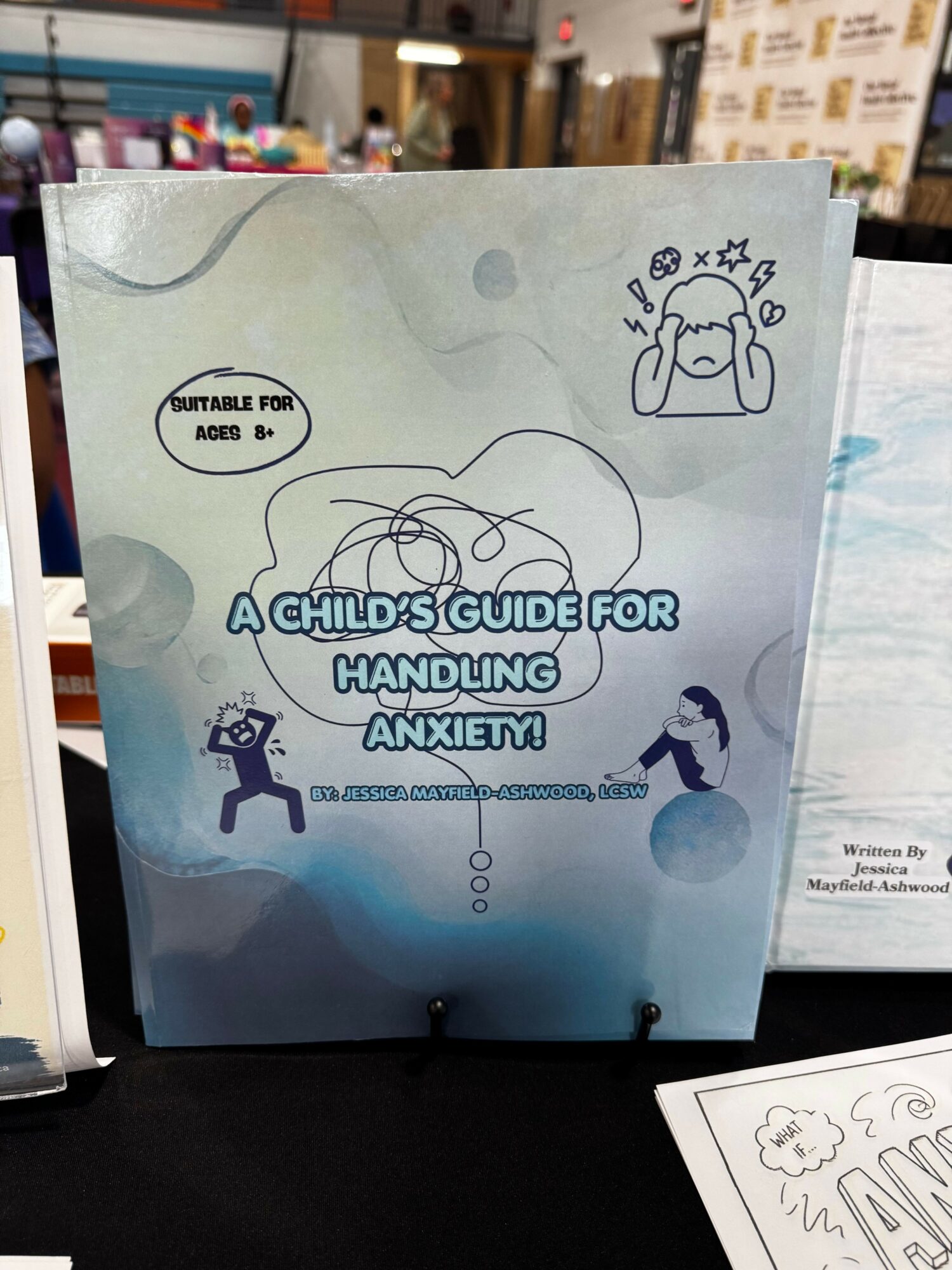 Guidebook titled 'A Child's Guide for Handling Max' with illustrations of a dog and a person, on a table.