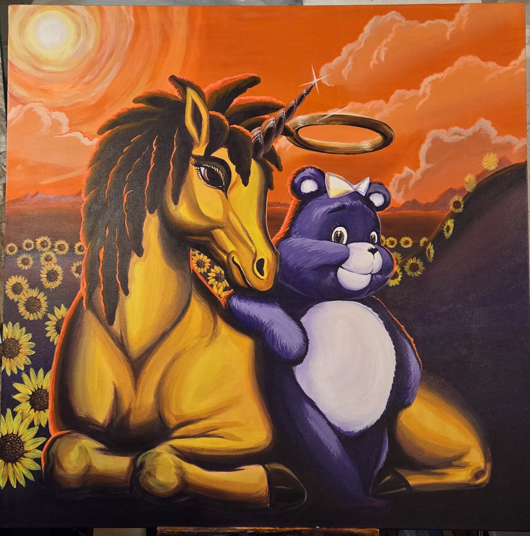A colorful painting of a yellow unicorn with a rainbow-colored mane and a purple bear sitting together in a sunflower field at sunset.
