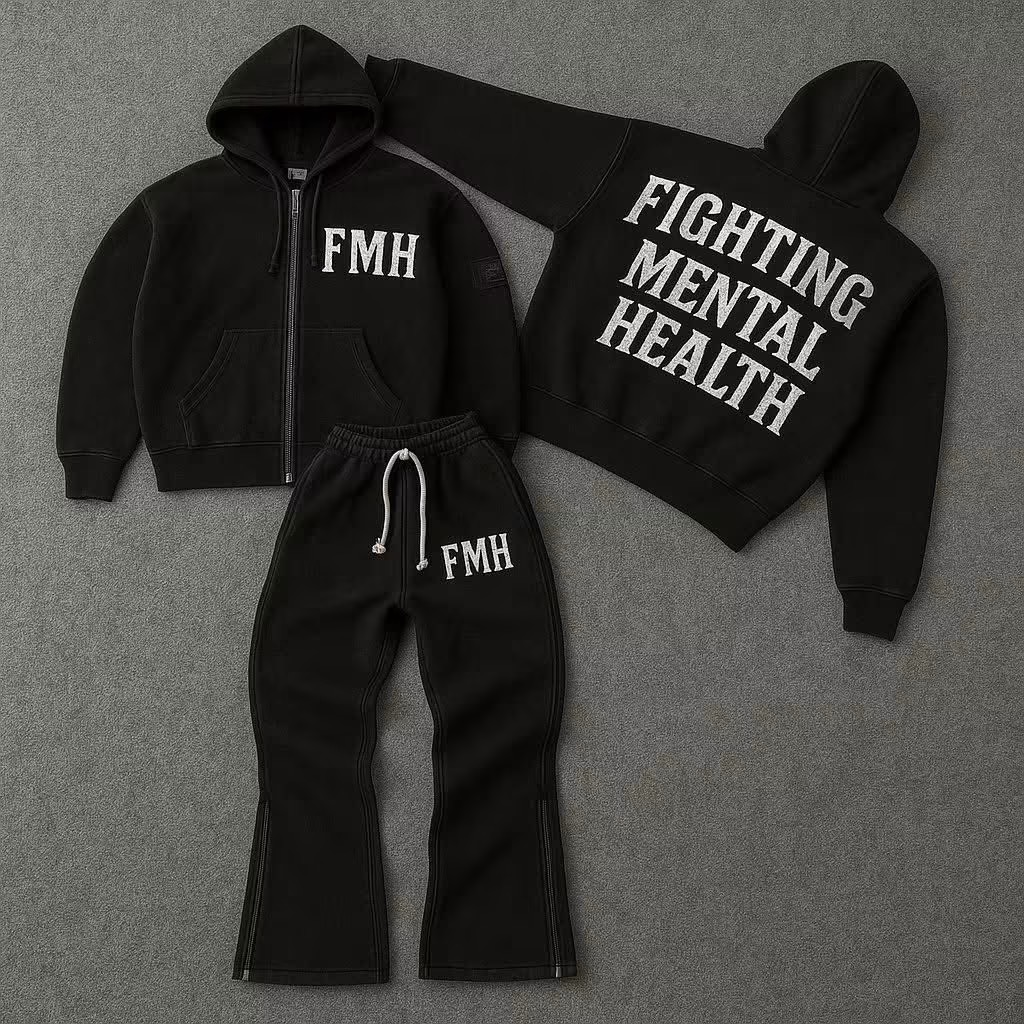 Black hoodie, sweatpants, and a bag with white text promoting mental health awareness, laid on a gray surface.