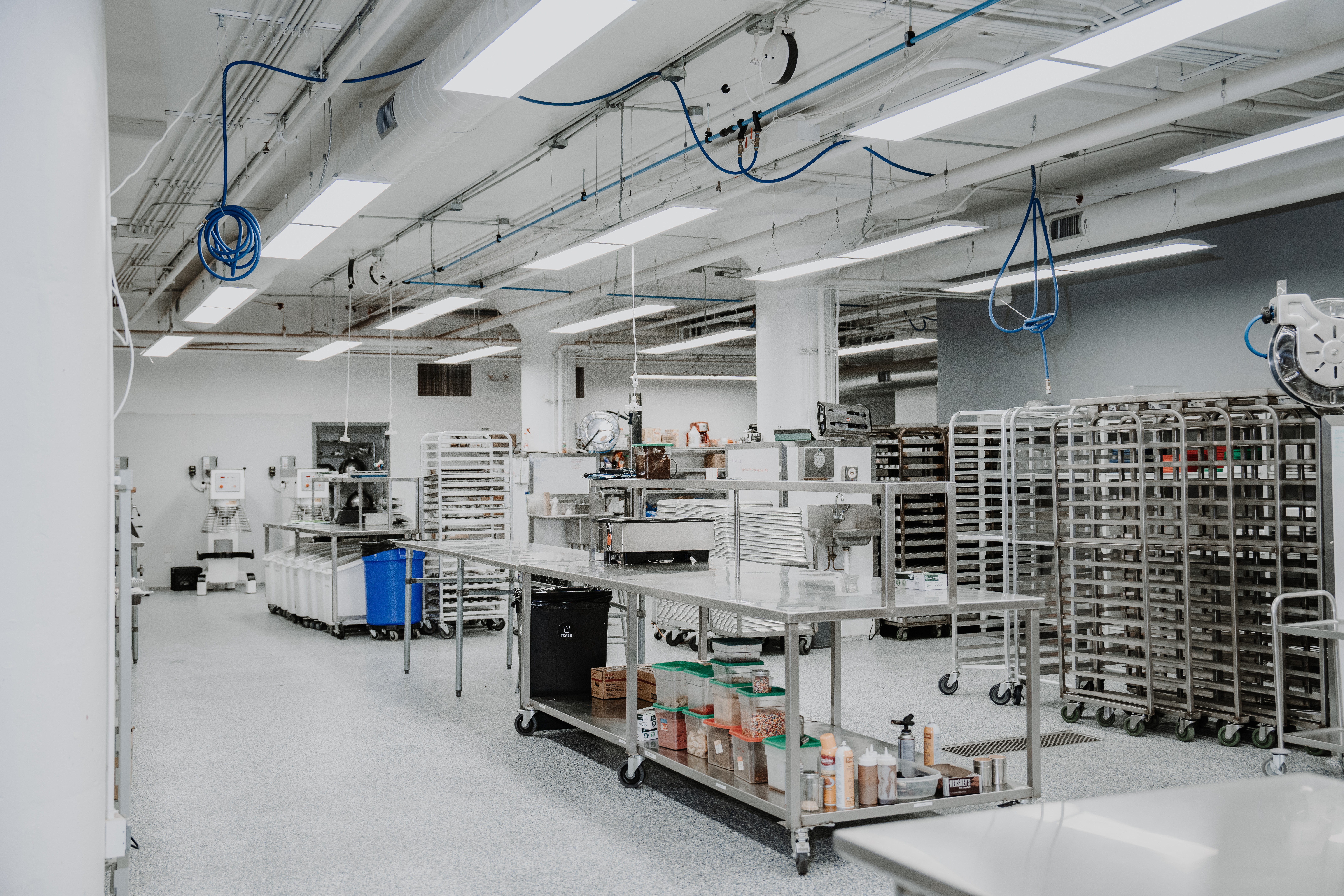 Industrial workspace with shelves, carts, and equipment in a clean, well-lit environment.