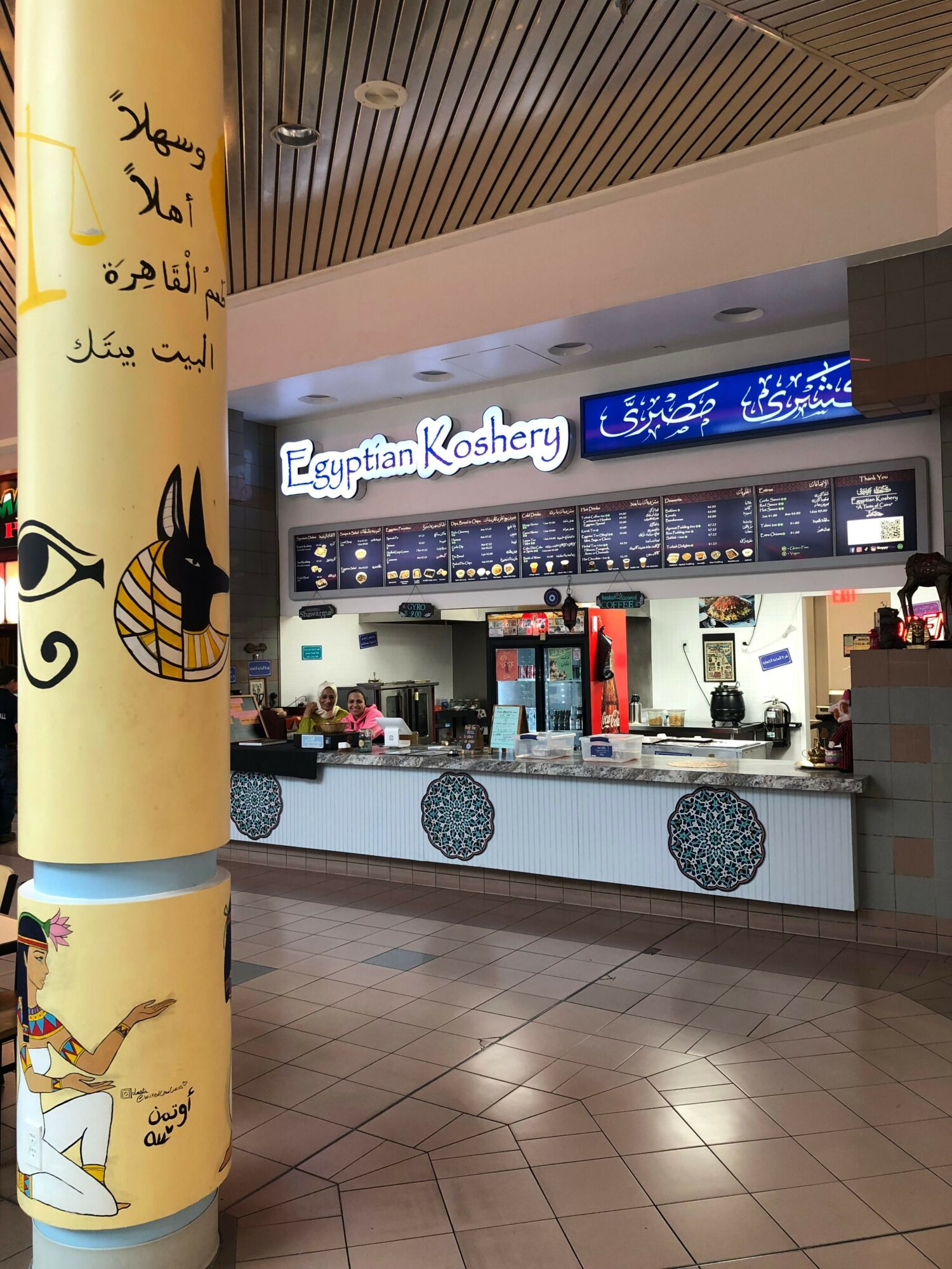 View of a reception area with a counter, digital display, and decorative elements, seen from the side. The image is rotated 90 degrees clockwise.