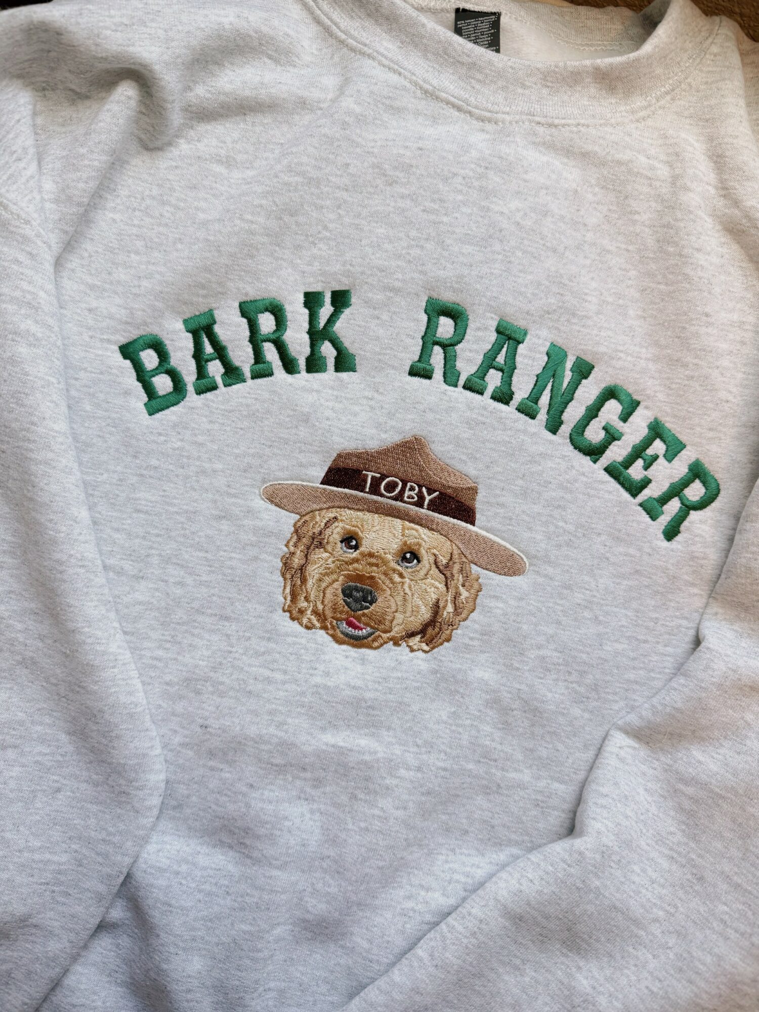 Gray sweatshirt with a dog wearing a hat and the text 'BARK RANGER' above it.