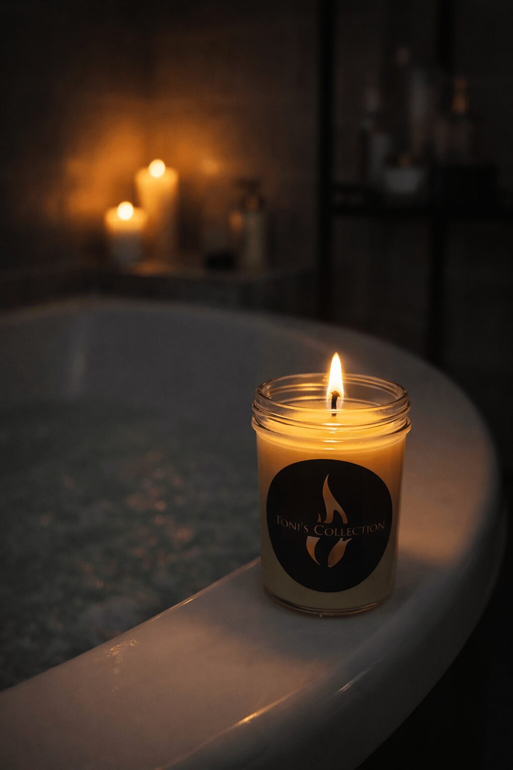Lit candle in a glass jar on the edge of a bathtub, with candles glowing in the background.