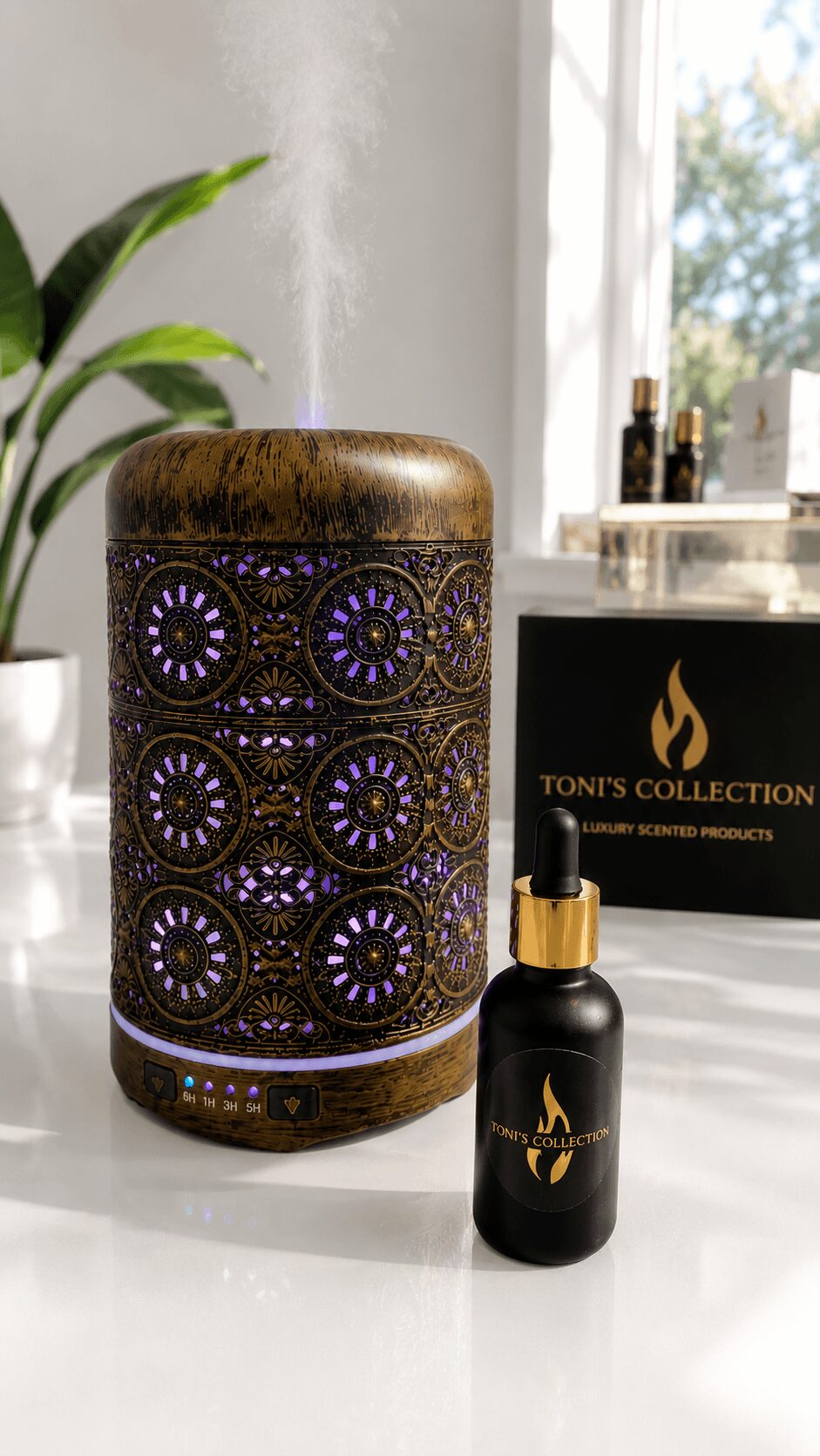 Decorative cylindrical object with purple patterns, small black bottle with gold dropper, and a box labeled 'Toni's Collection' on a white surface.