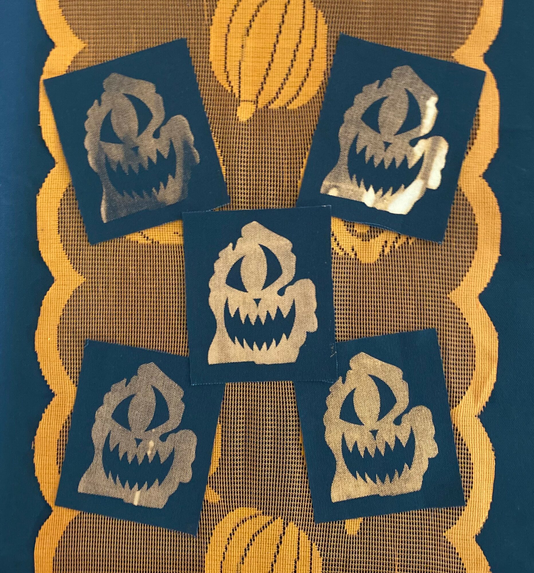 Six cards with a menacing pumpkin face design arranged in a circular pattern on a decorative background.