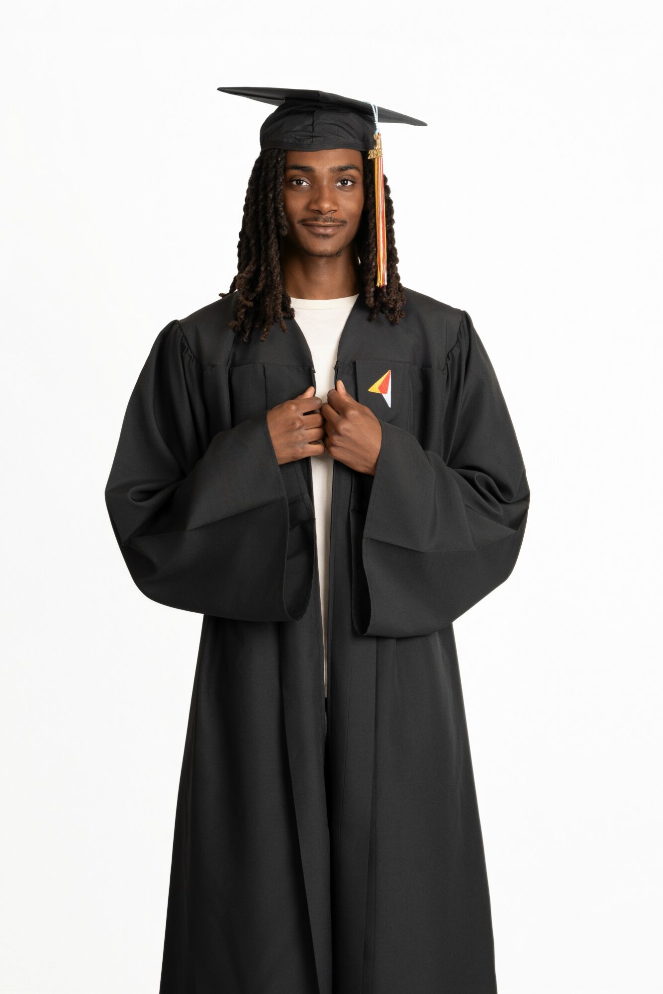Young person in graduation gown and cap, holding the gown with both hands, smiling, against a white background.