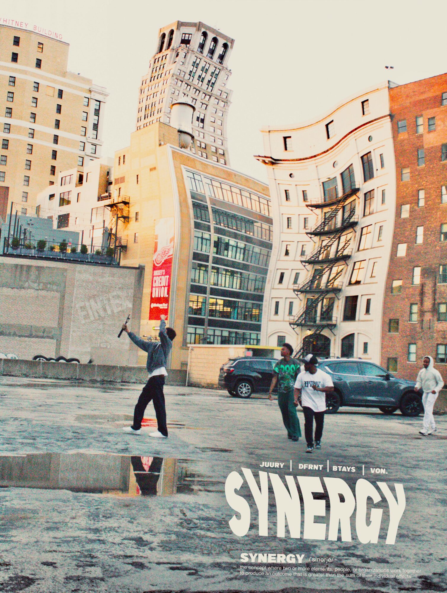 People walking and standing on a city street with tall buildings in the background, and a reflection on wet pavement, with the word 'SYNERGY' at the bottom.