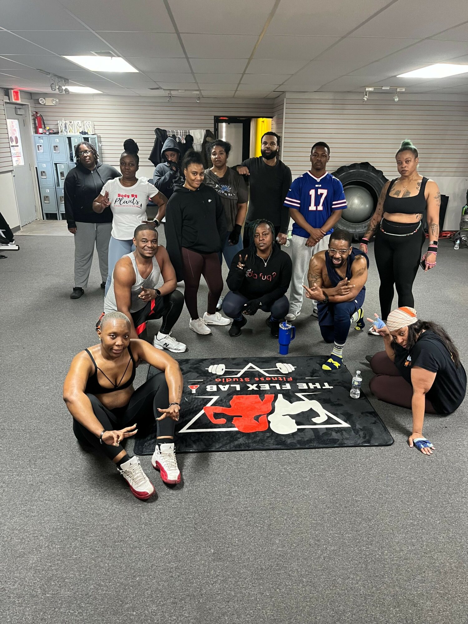 Group of people, including a woman in a sports bra, posing in front of a Z2 fitness equipment in a gym.