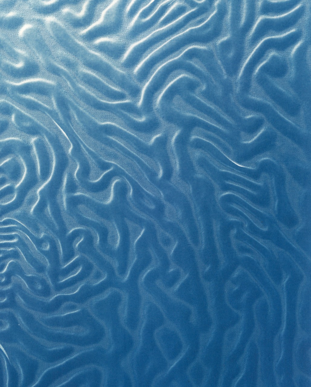 Close-up of textured blue surface with wavy, irregular patterns.