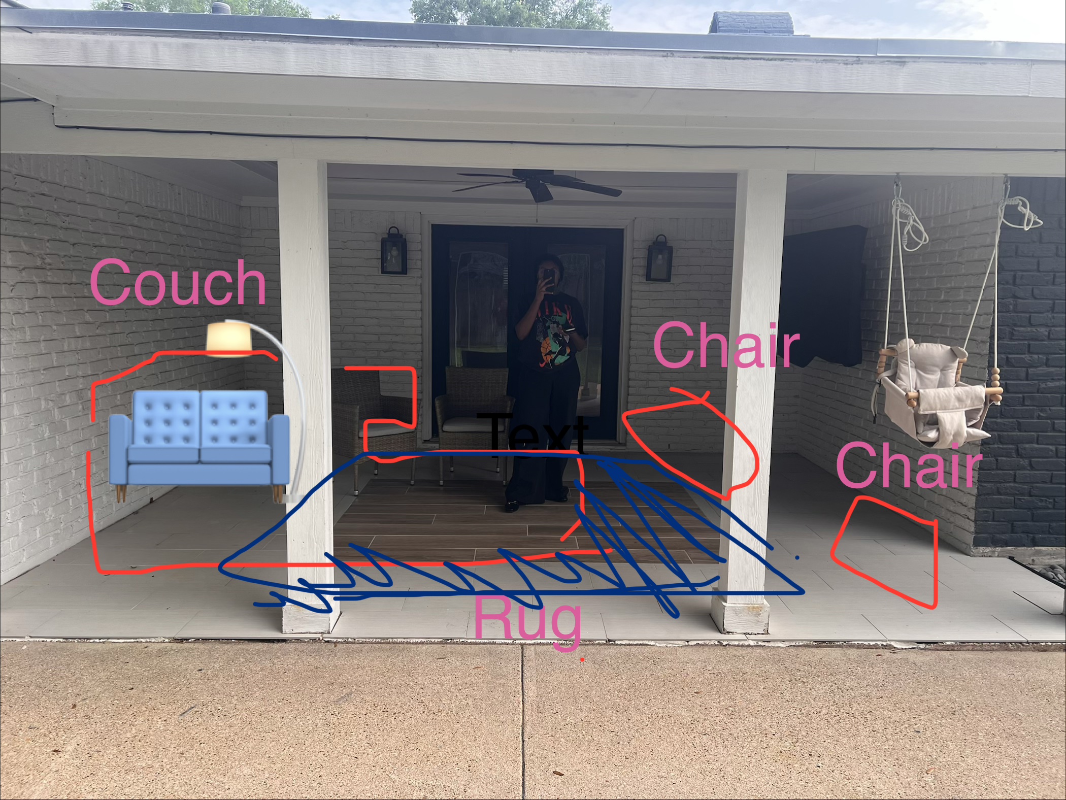Person standing in doorway with porch furniture including a blue couch, a rug, and two chairs, one with a swing, on porch.