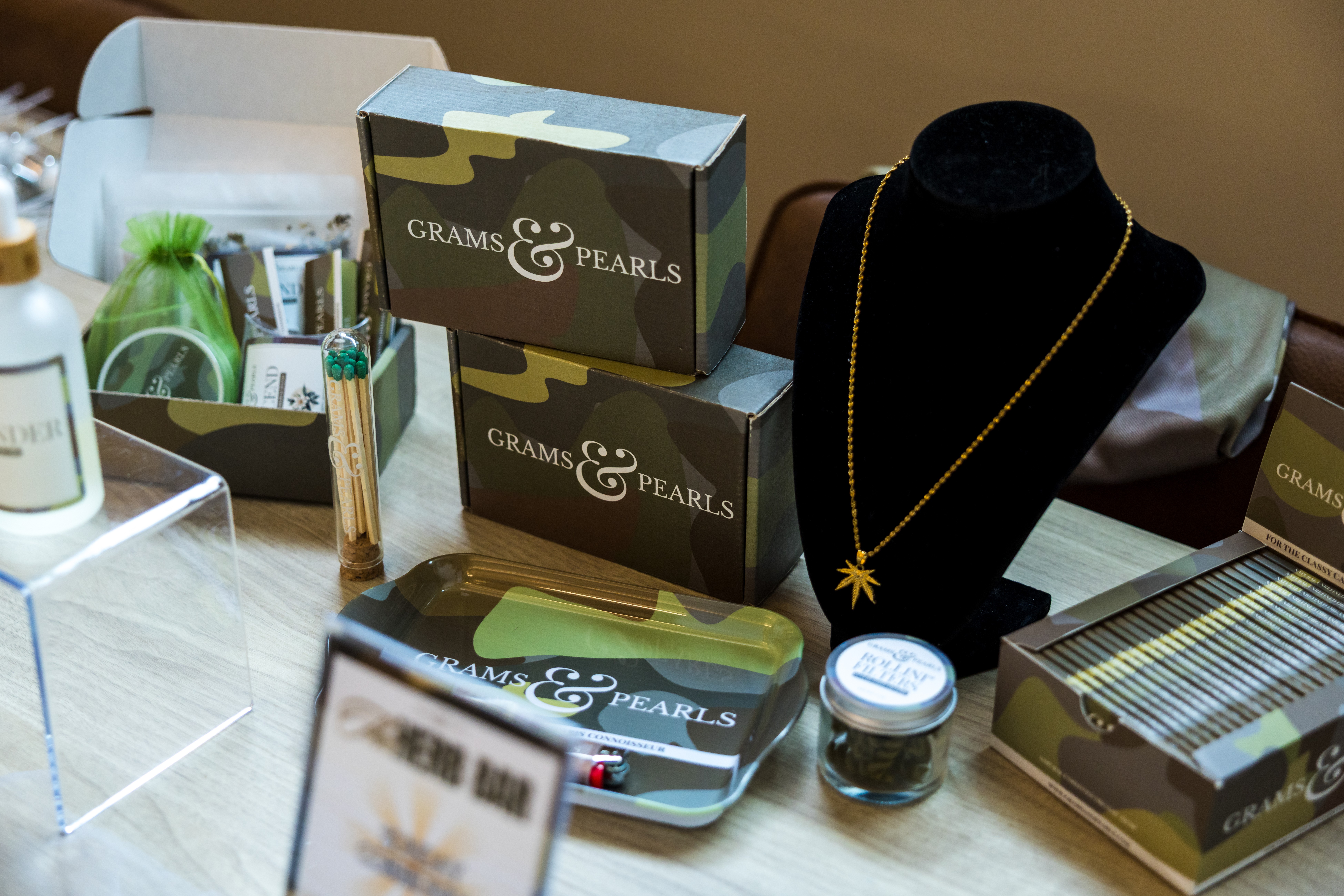 Display of jewelry and boxes, including a necklace on a black bust, with various boxes and items on a table.