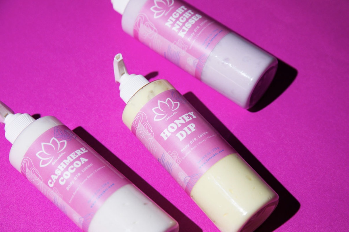 Three bottles with pink labels and white caps on a pink background, labeled honey dip and caramel cocoa.
