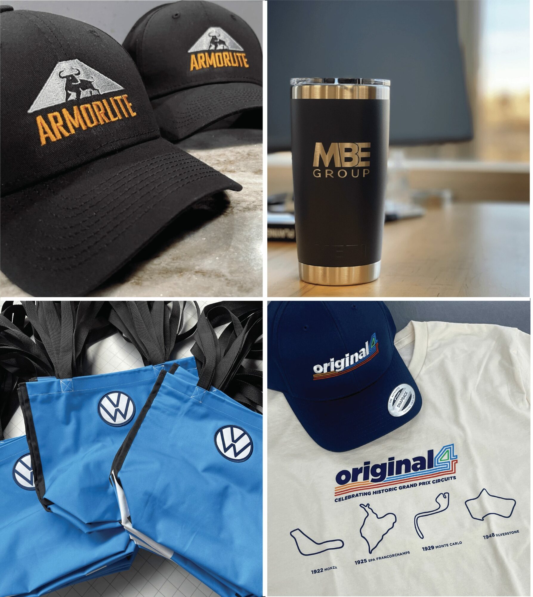 Two black caps with 'ARMORLITE' logo, black tumbler with 'MBE GROUP' logo, blue bags with Volkswagen logo, and a white cap with 'original' logo and race track outlines.