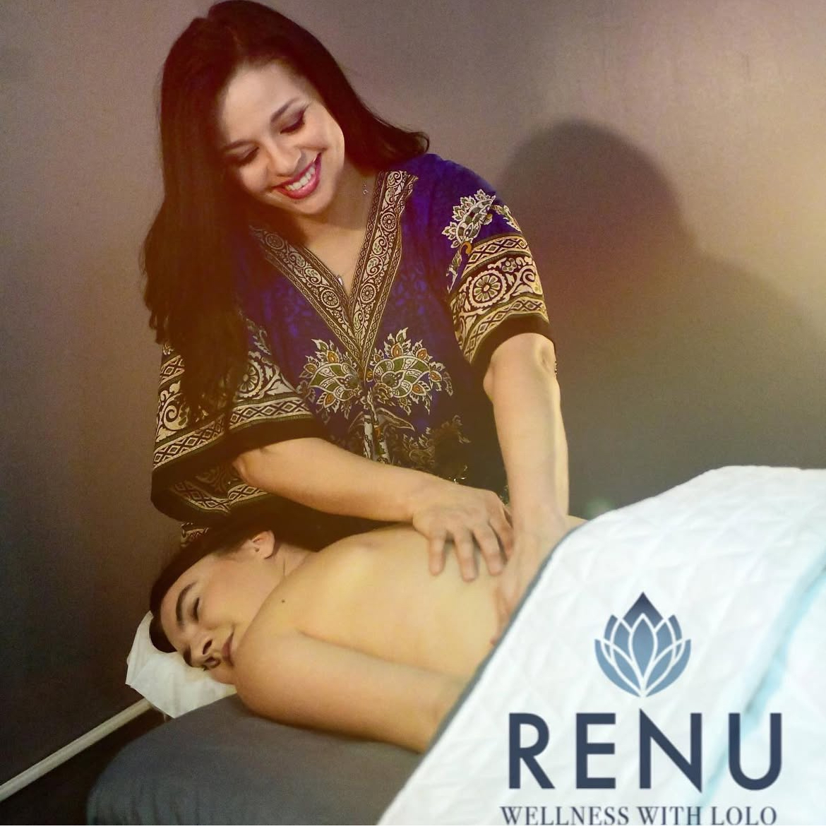 Woman giving massage to person lying face down on massage table, wellness logo and text in corner