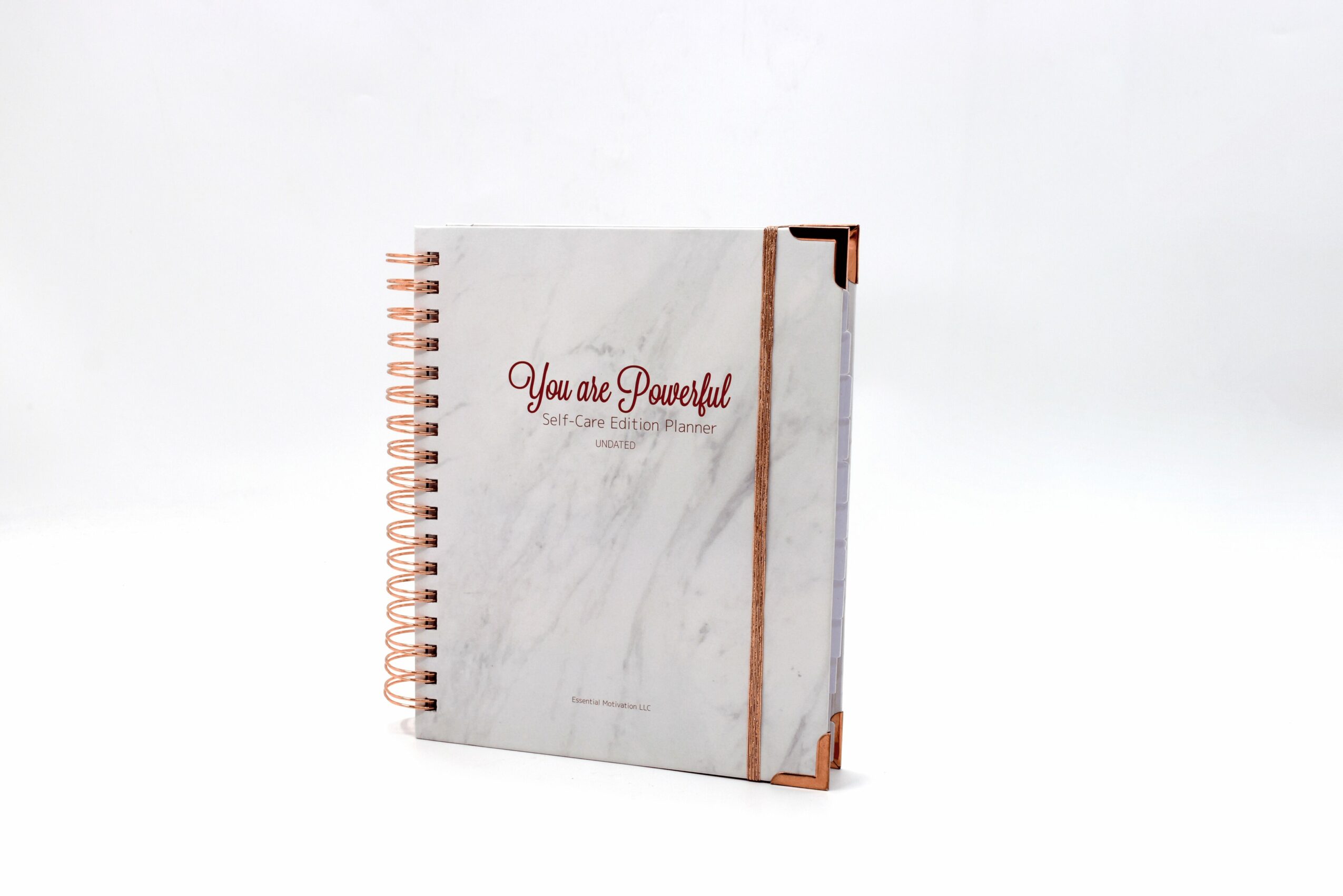 A spiral-bound notebook with a marble cover and a brown elastic band, with the text 'You are Powerful' in red.