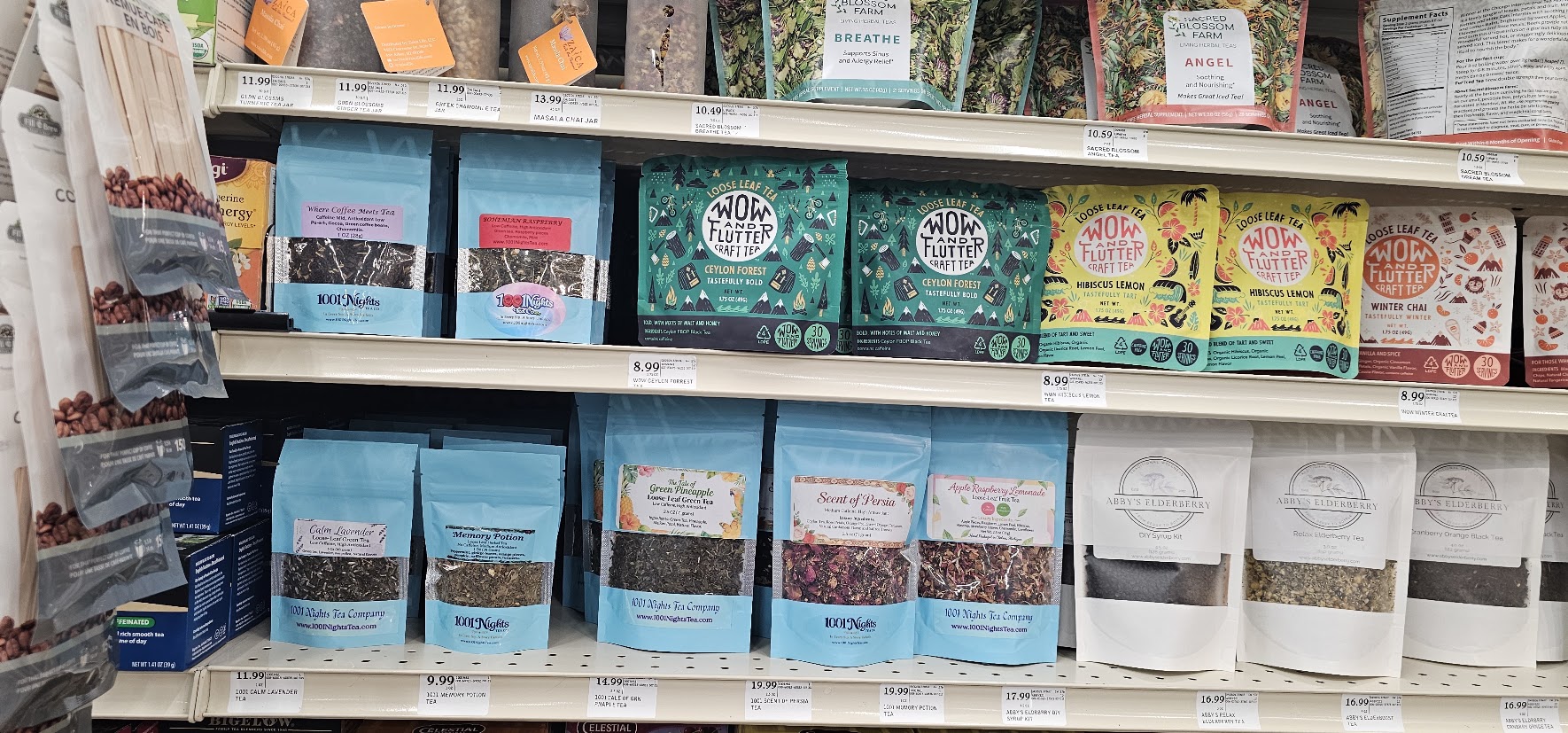 Shelf with various tea boxes arranged in rows, colorful packaging, and labels visible.