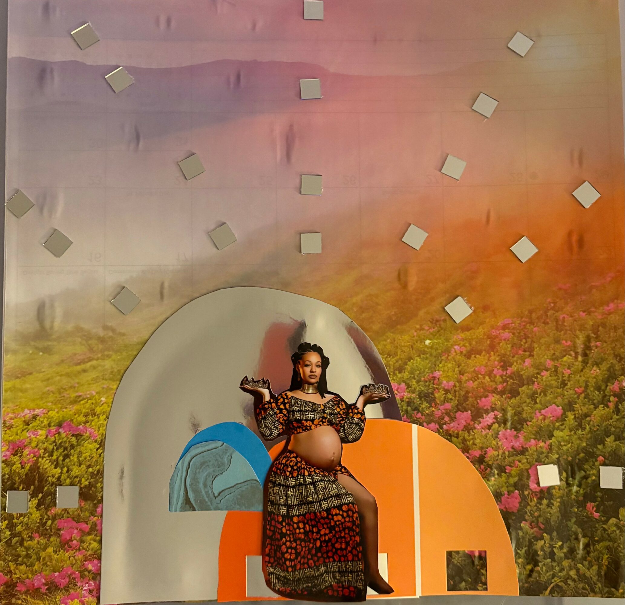 Person sitting on a stage with a colorful backdrop, wearing a patterned dress, holding a microphone, with a large belly.