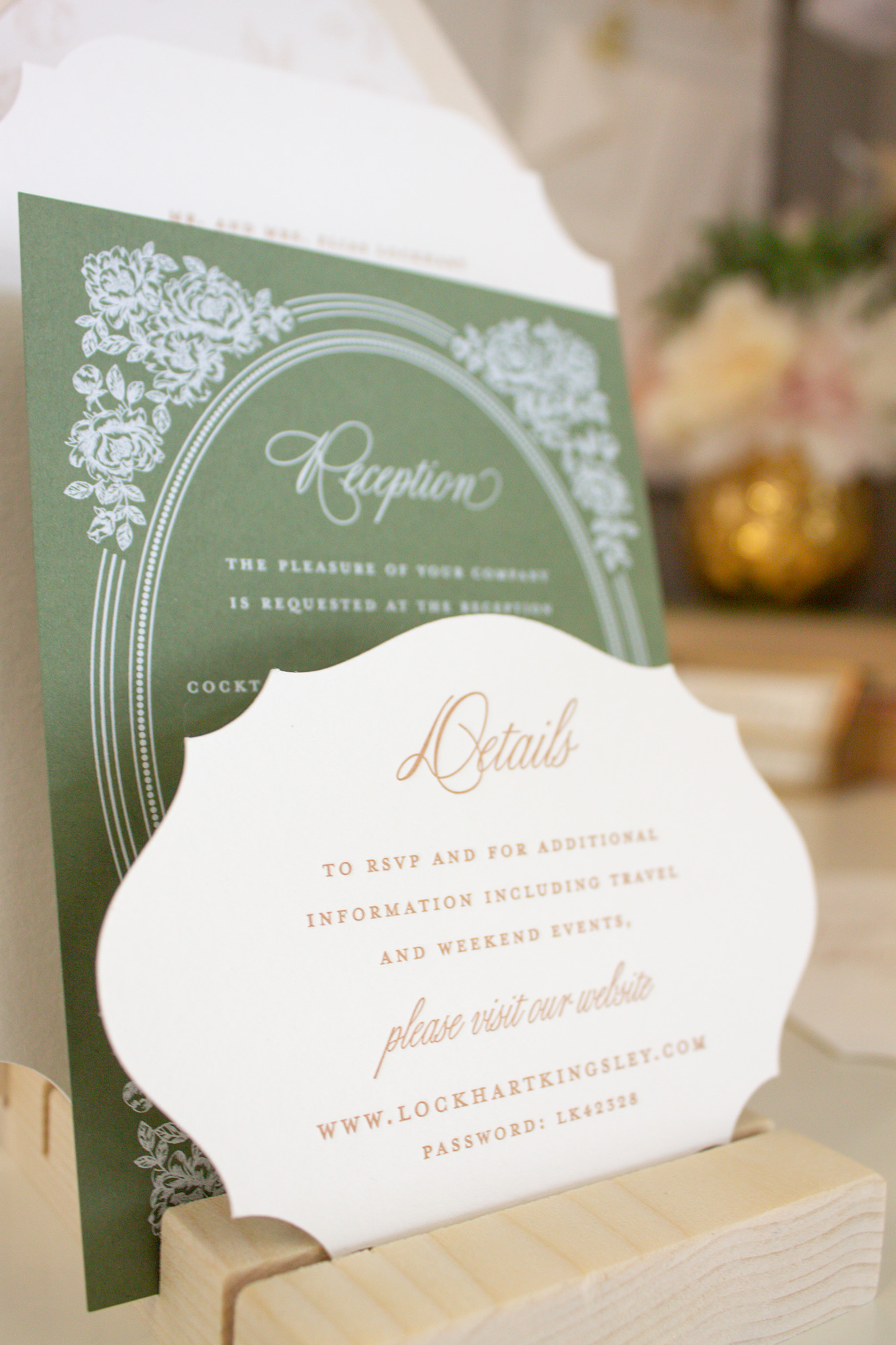 Green reception sign with white decorative border and text, and a white detail card with gold and brown text, on a wooden surface.