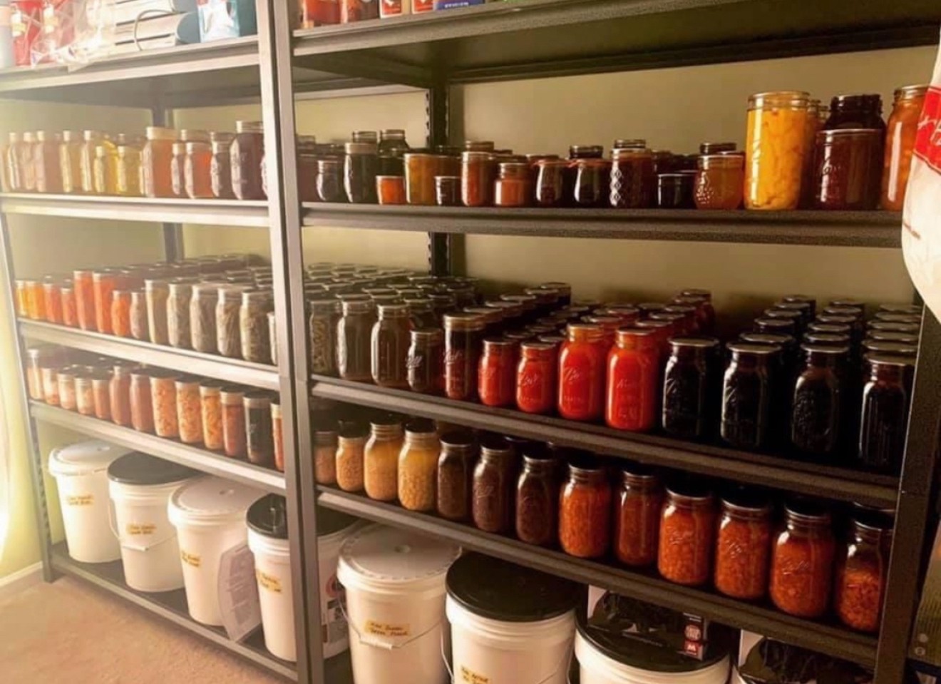 Shelves filled with jars of spices and containers in a store, organized by color and type.
