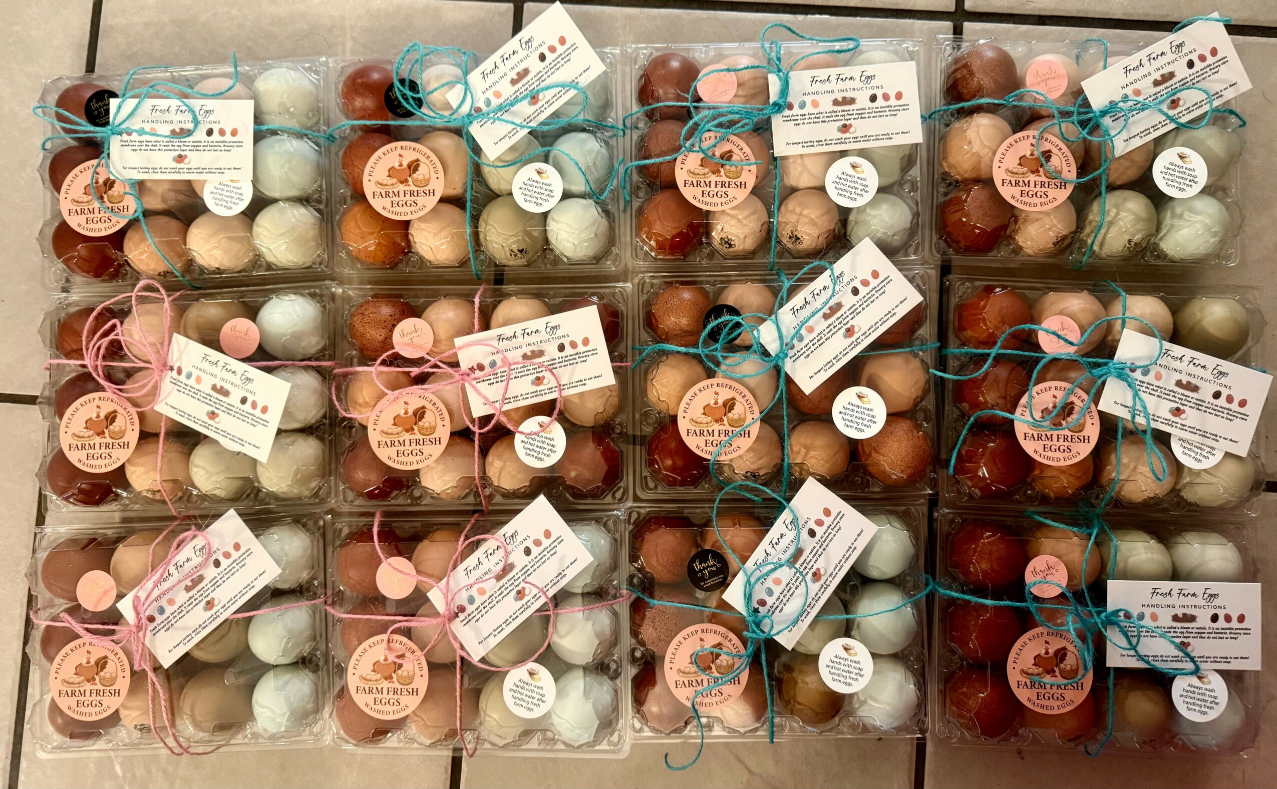 Multiple boxes of assorted colored eggs wrapped with ribbons and tags, arranged in rows.