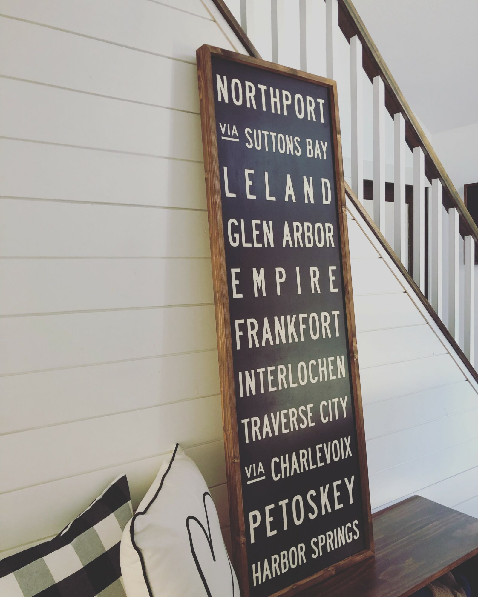 Vertical signboard listing locations including Northport, Leland, Glen Arbor, Empire, Frankfort, Interlochen, Traverse City, Petoskey, and Harbor Springs.