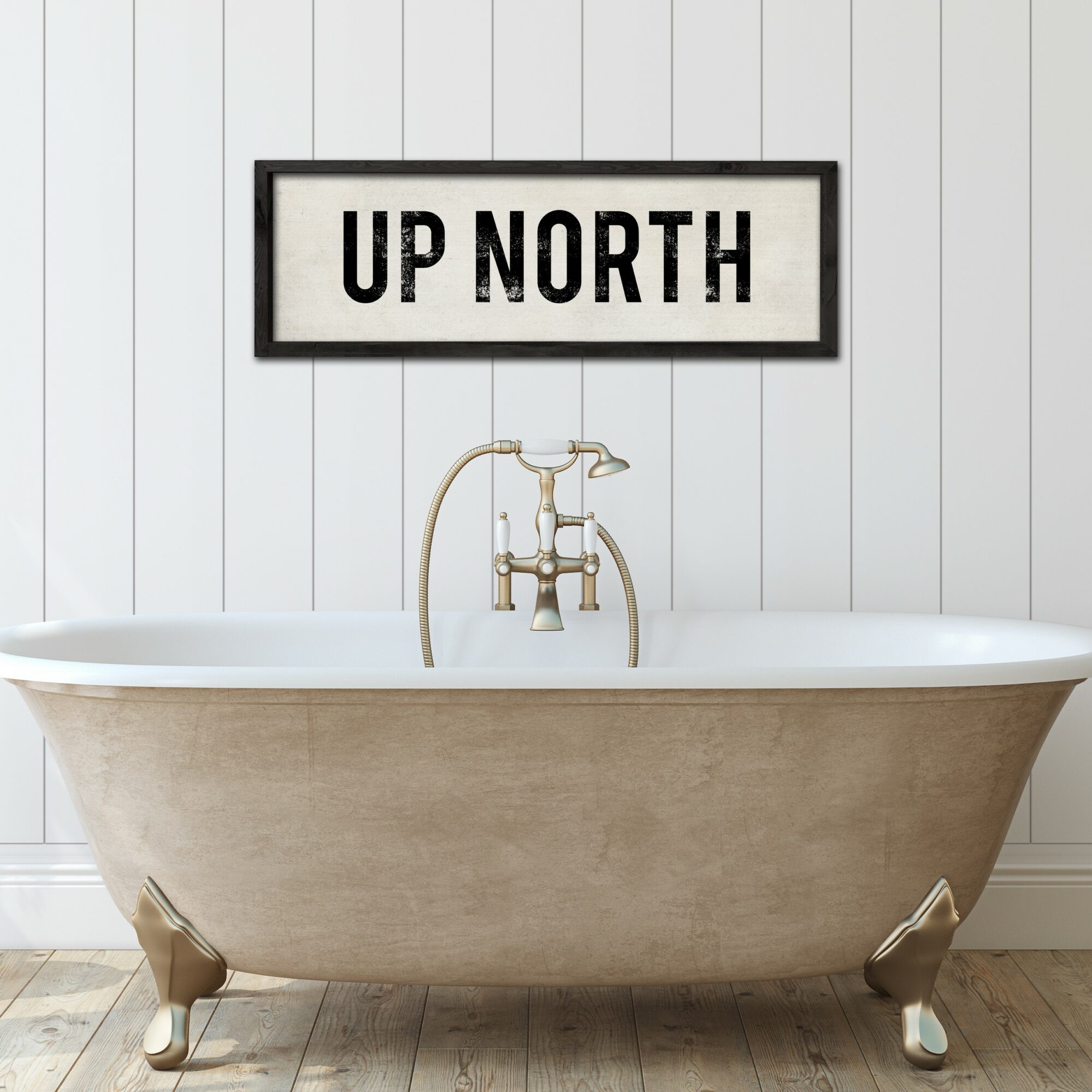 Freestanding bathtub with a faucet, wall sign reading 'UP NORTH', and wooden floor, against white paneled wall.