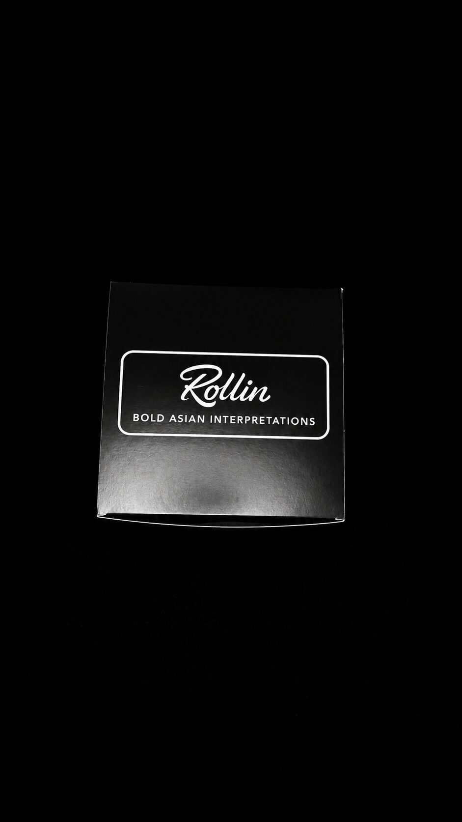 A black box with white text reading 'Rollin' and 'Bold Asian Interpretations' on a dark background.
