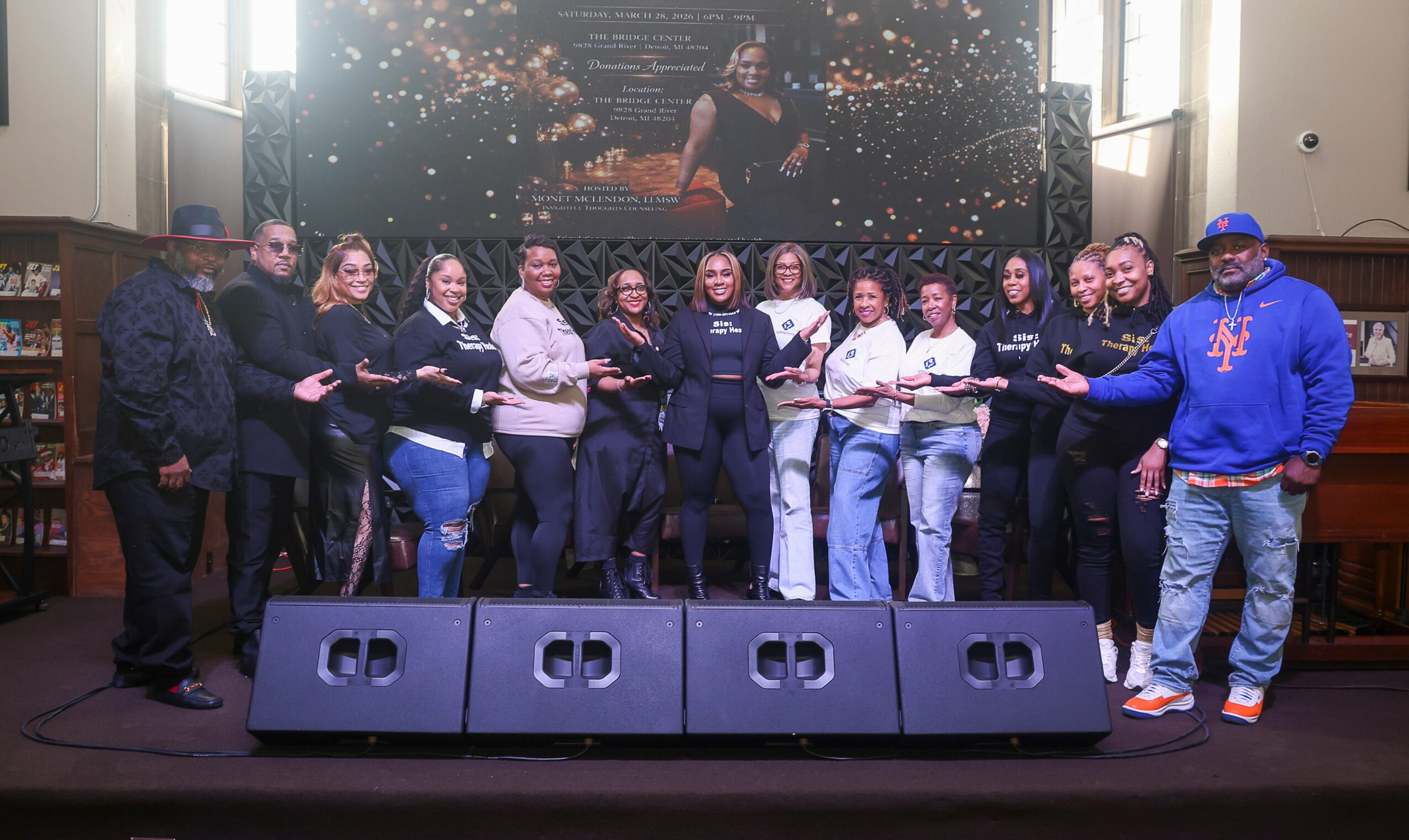 Group of people on stage holding awards, with a large screen behind showing a woman and city lights.