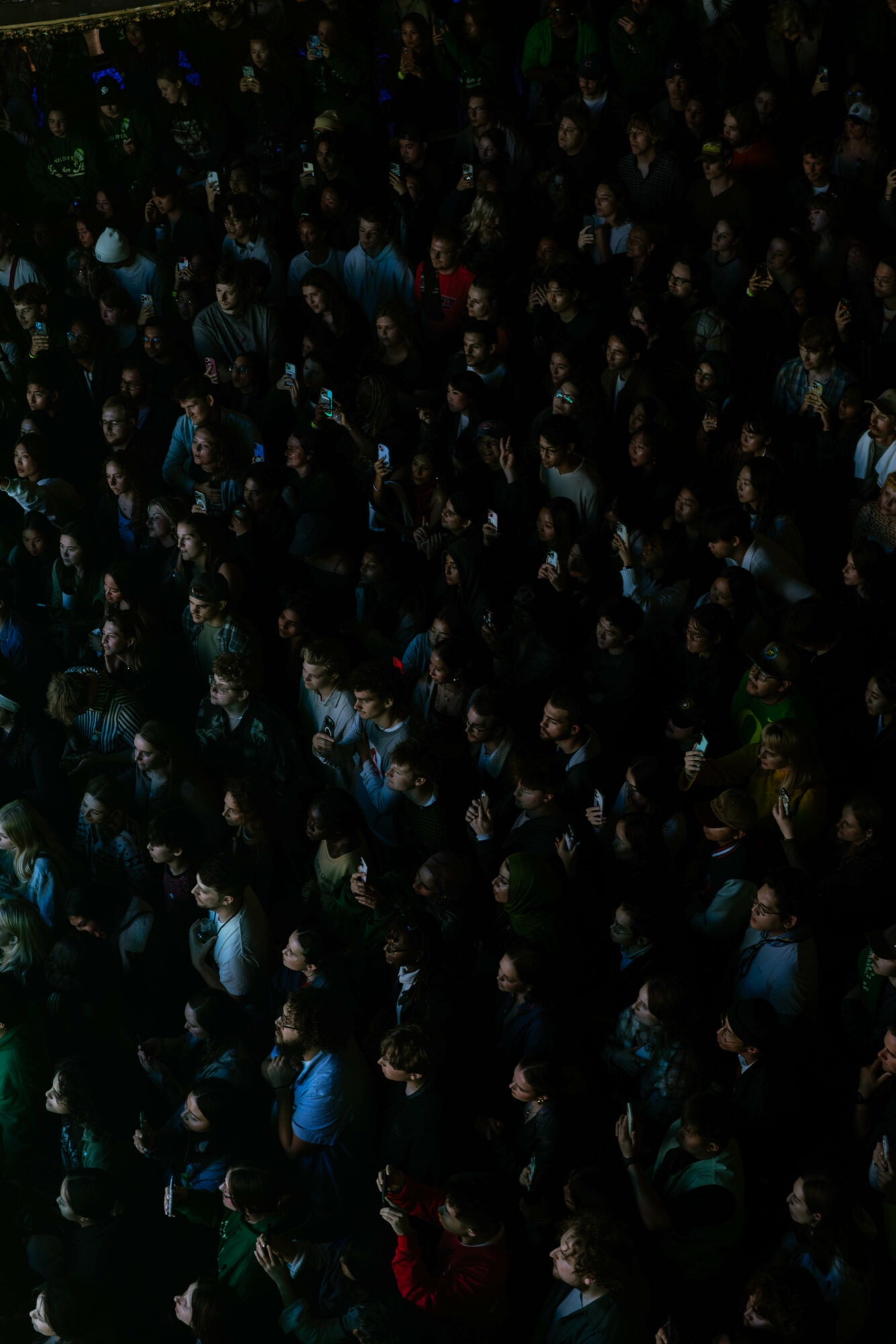 Crowd of people gathered closely together, viewed from above, with some wearing blue and others in darker clothing.